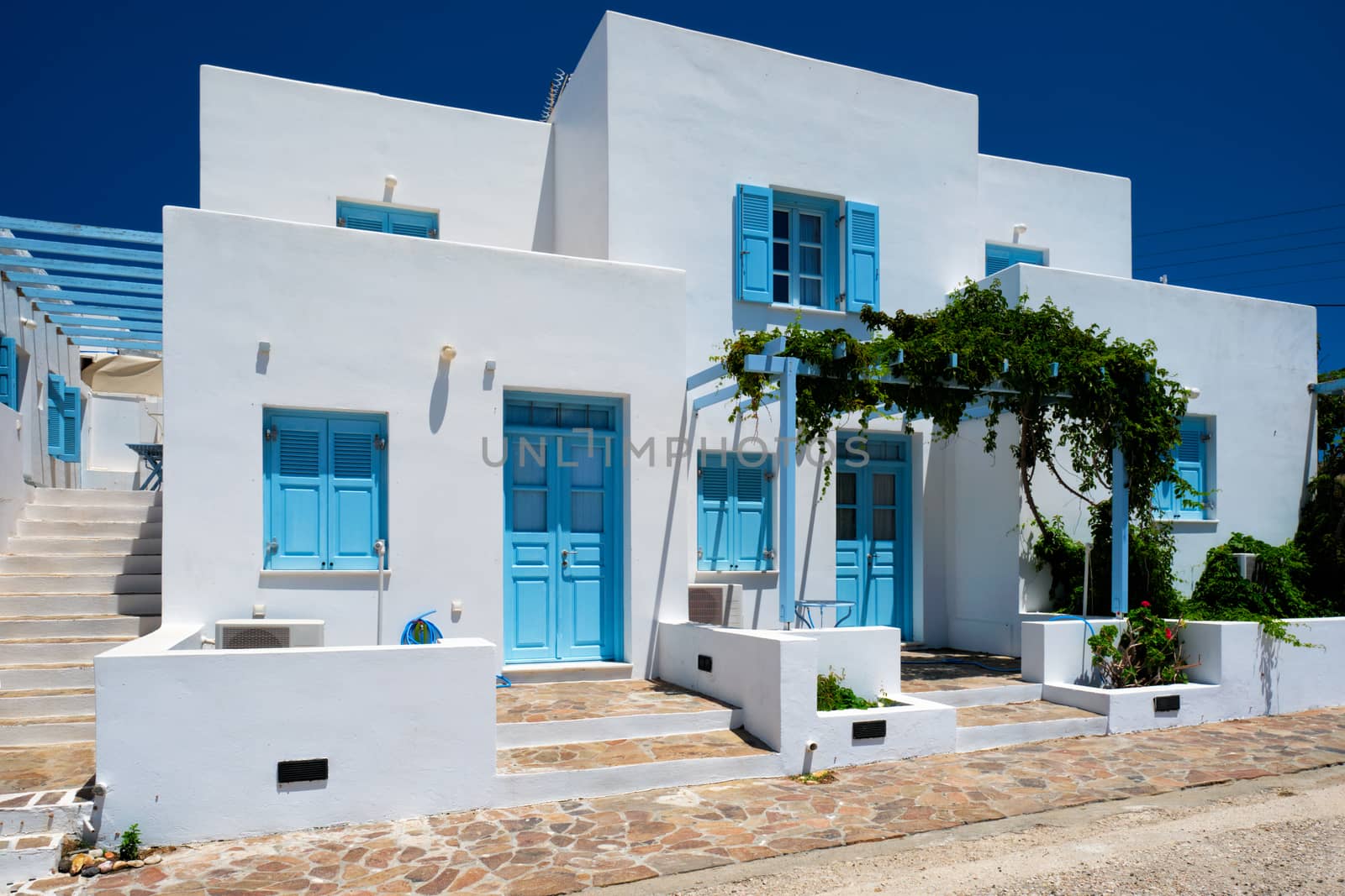 Traditional greek architecture - houses painted white with blue doors and window shutters. Pachena village, Milos island, Greece