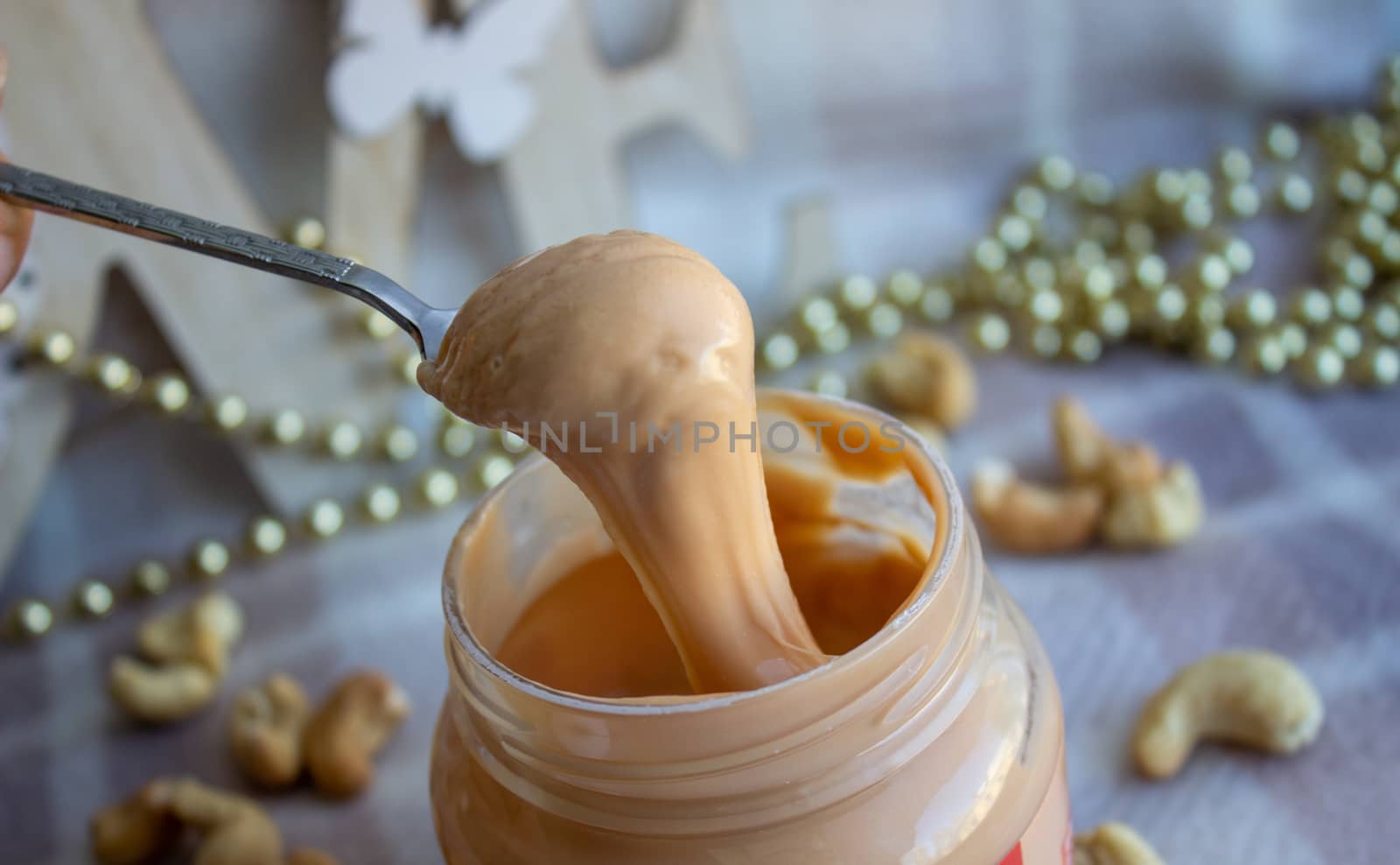 Creamy peanut butter and spoon on background.