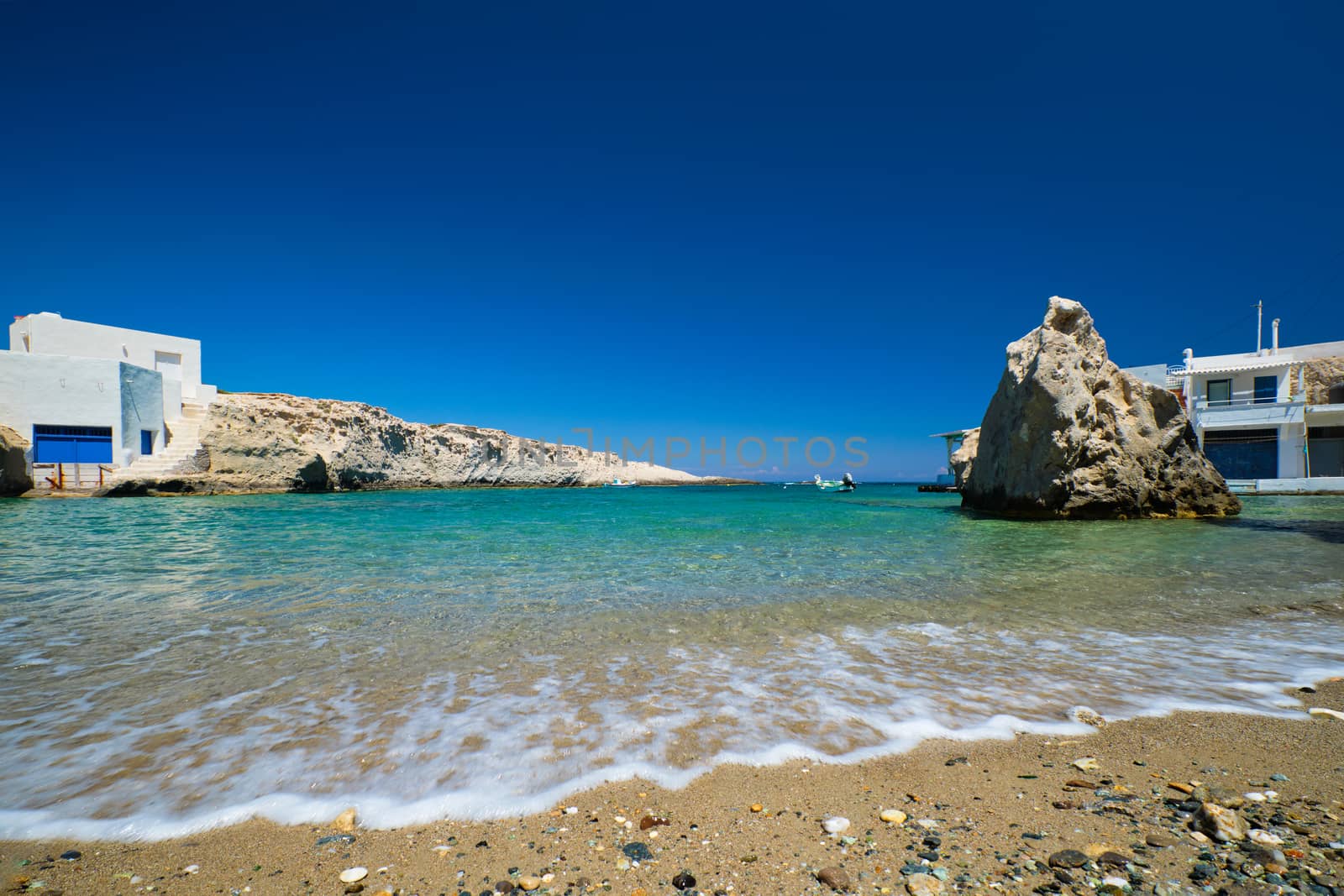 Crystal clear blue water at MItakas village beach, Milos island, Greece. by dimol