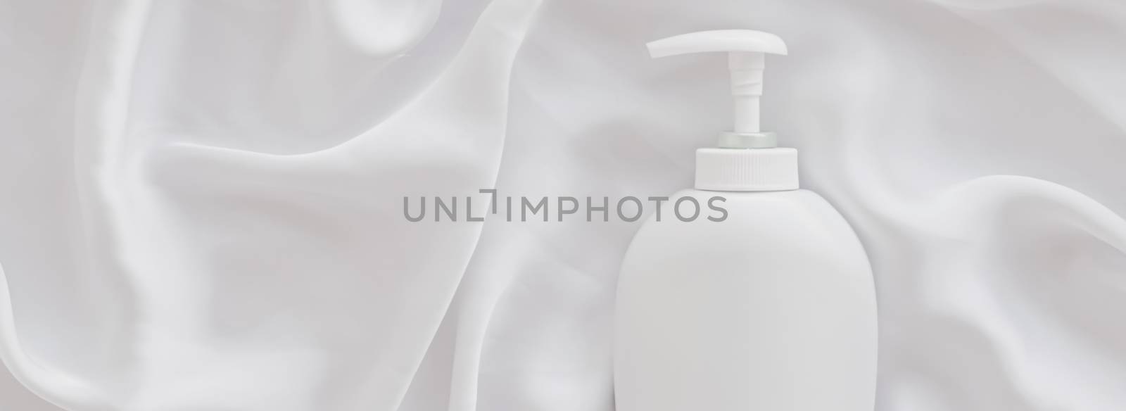 Blank label cosmetic container bottle as product mockup on white silk background by Anneleven