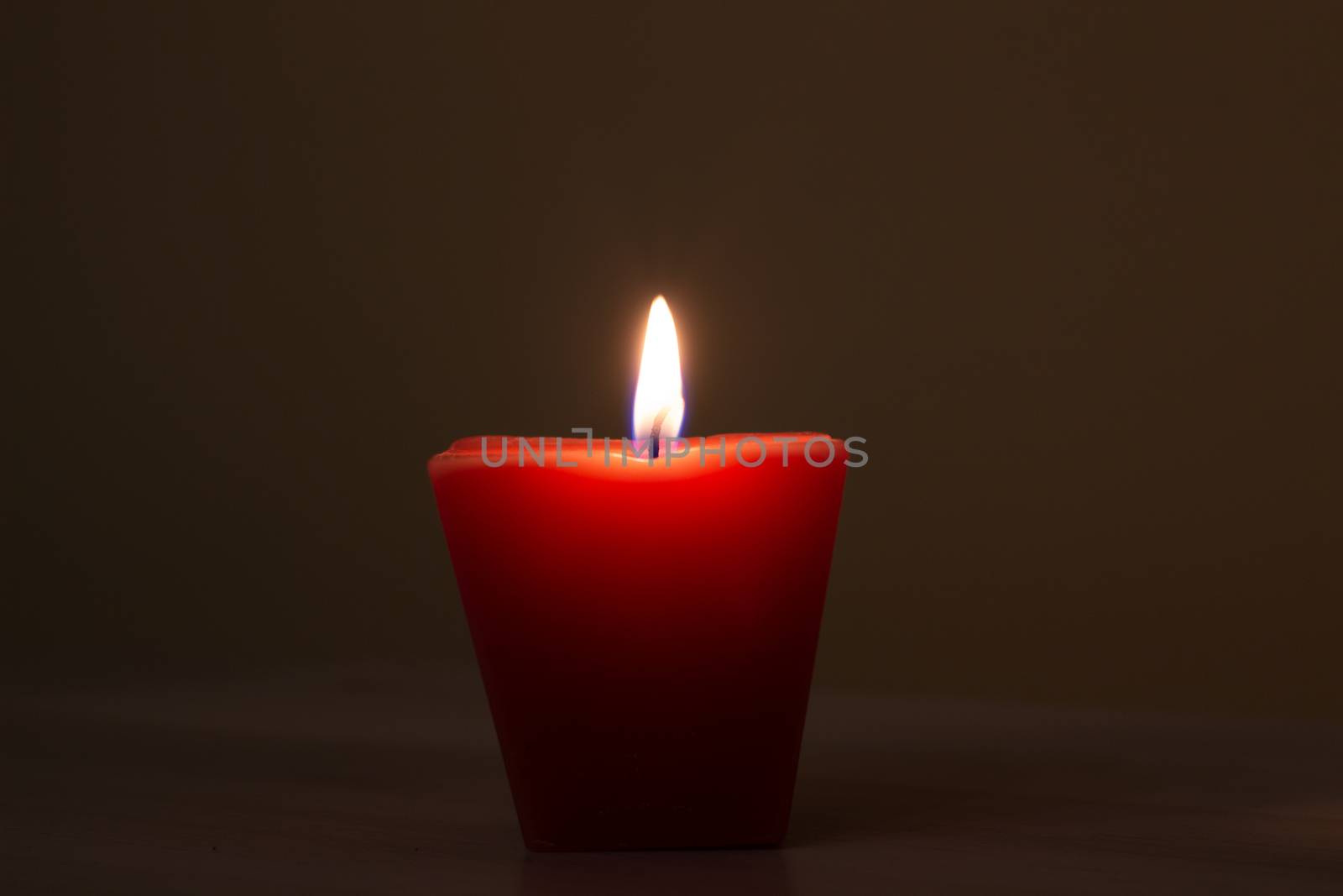 Closeup of burning candle isolated on black background.