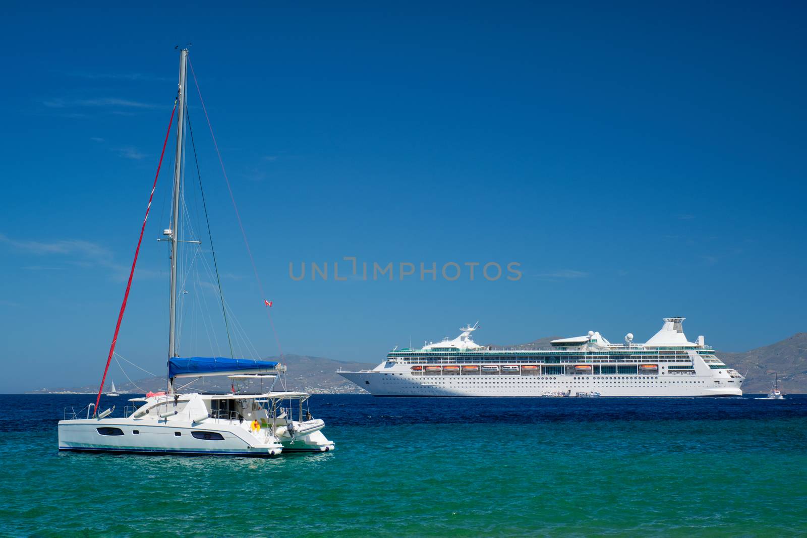 Catamaran yacht and cruise liner is Aegean sea. Chora, Mykonos island, Greece by dimol