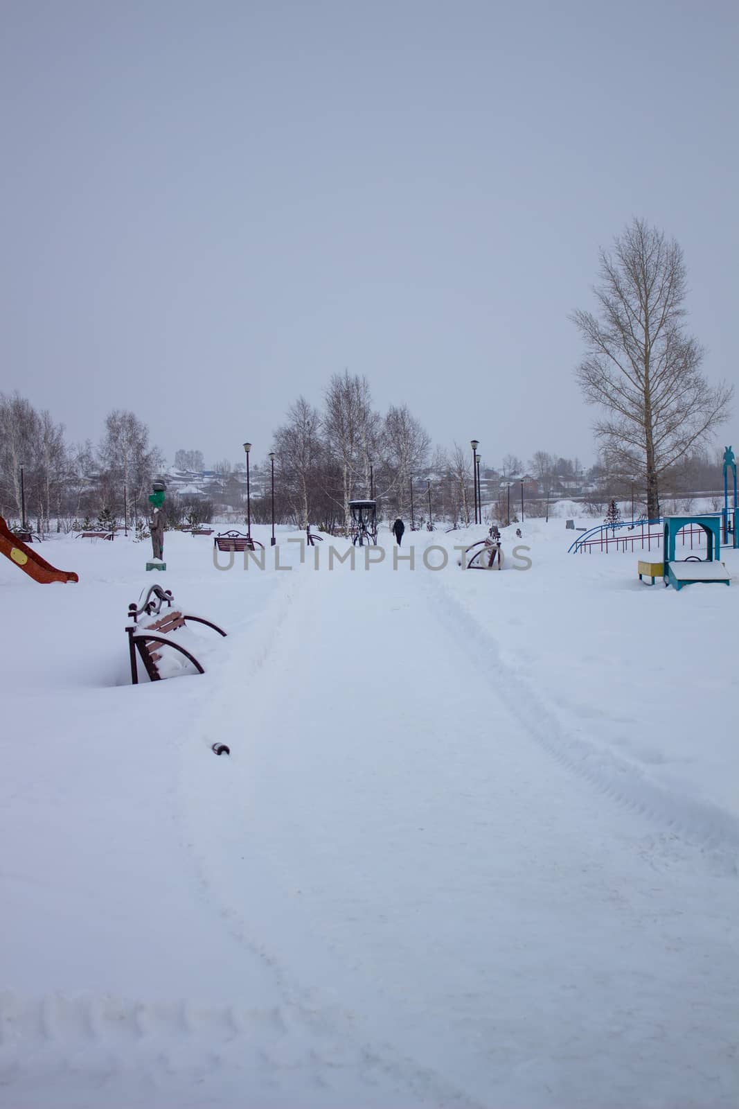 Paths in the winter Park. Bench, Playground for children