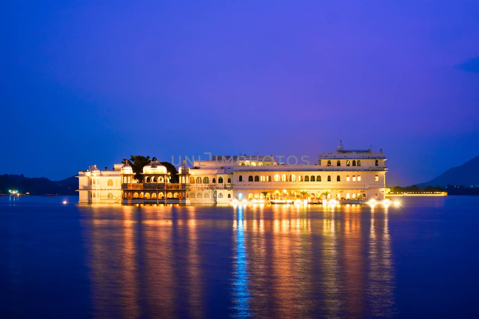 Romantic luxury India travel tourism - Lake Palace (Jag Niwas) complex on Lake Pichola in twilight, Udaipur, Rajasthan, India