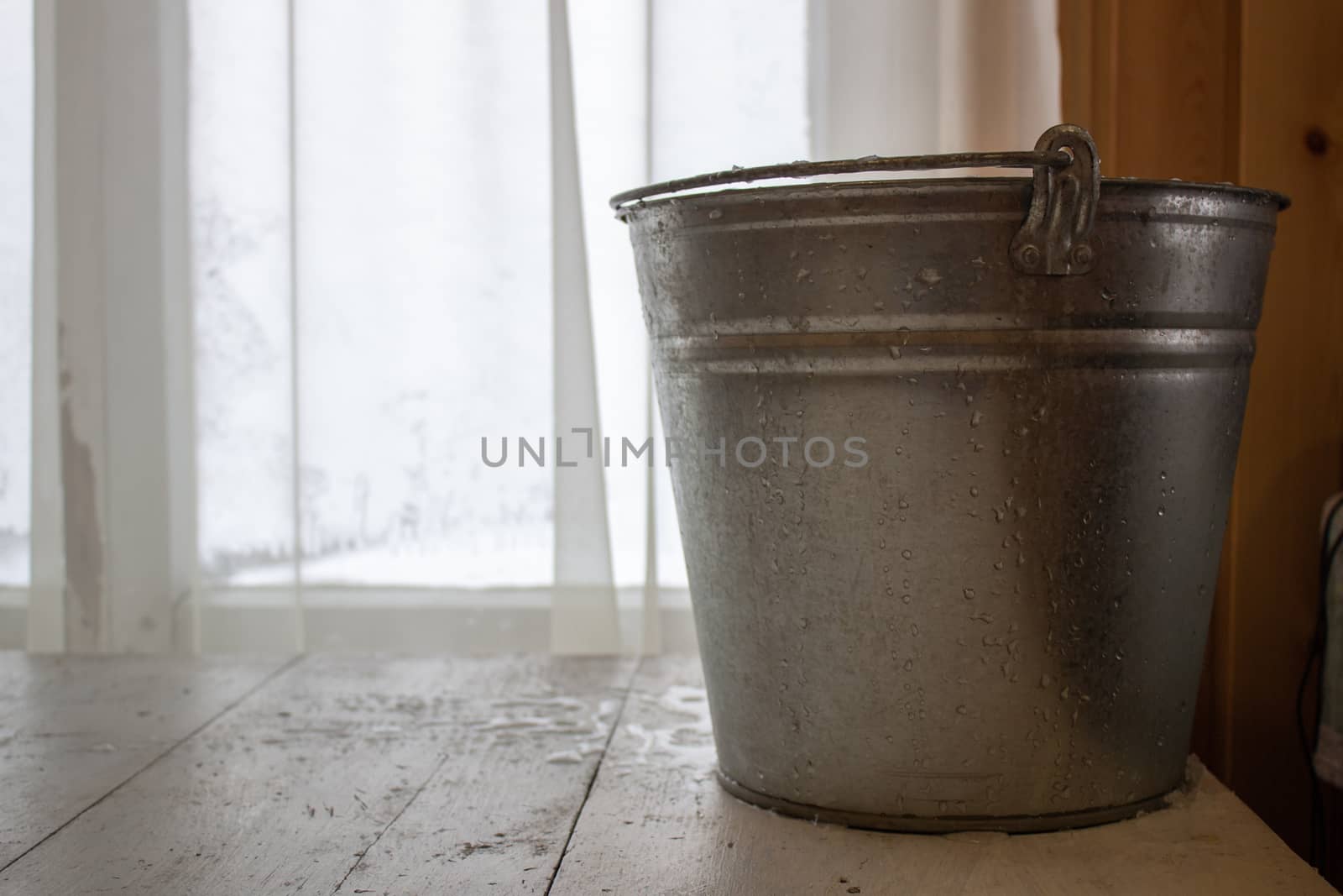 Bucket of water on the table in the cold. Close-up of an ice bucket on the background