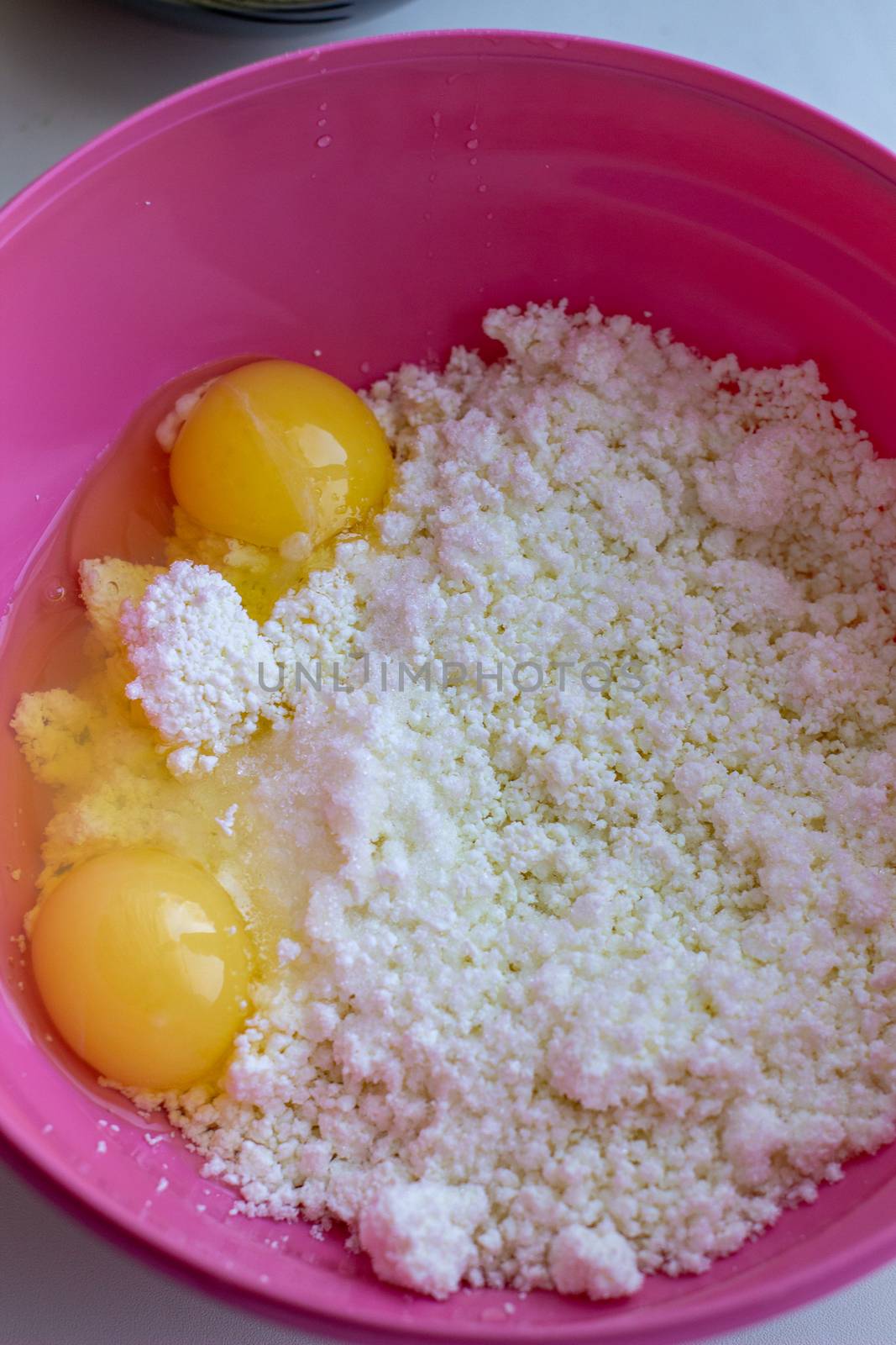 Cottage cheese with eggs in a glass cup on a wooden board. Cheesecake recipe