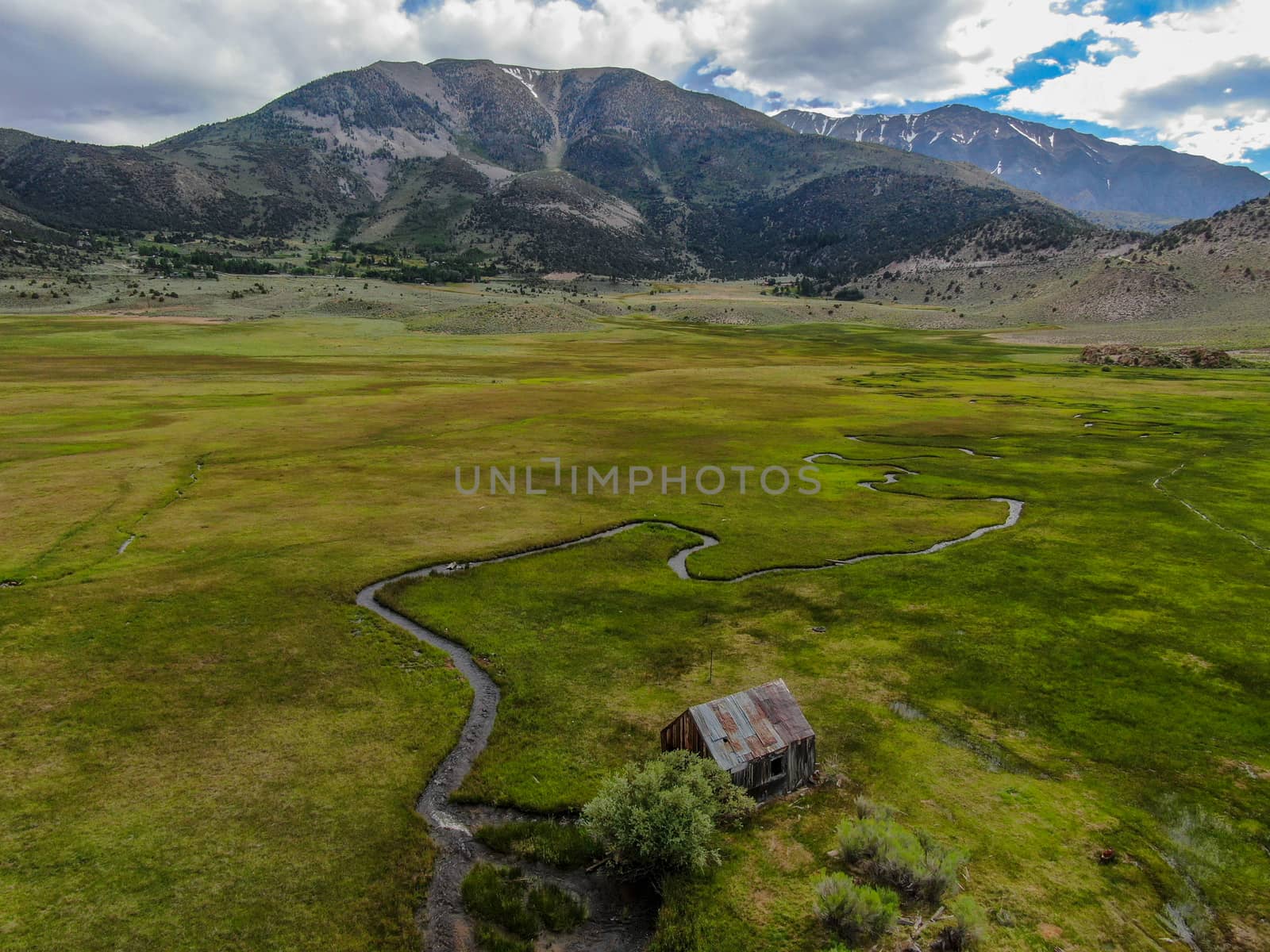 Aerial view of abandoned little wooden house barn next small river in the green valley, Aspen Spring by Bonandbon