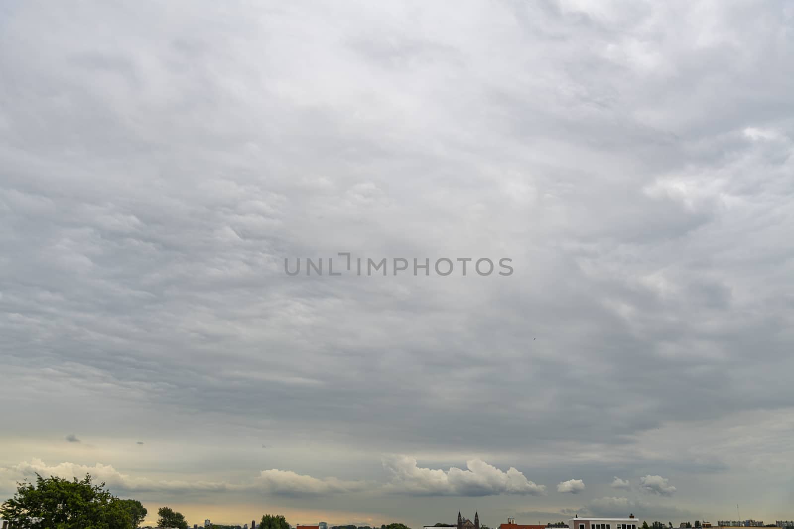 Early cloudy sunset before the storm over the cityscape by ankorlight