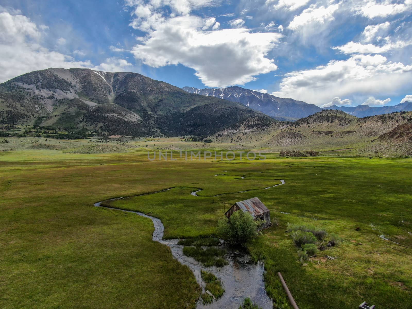 Aerial view of abandoned little wooden house barn next small river in the green valley, Aspen Spring by Bonandbon