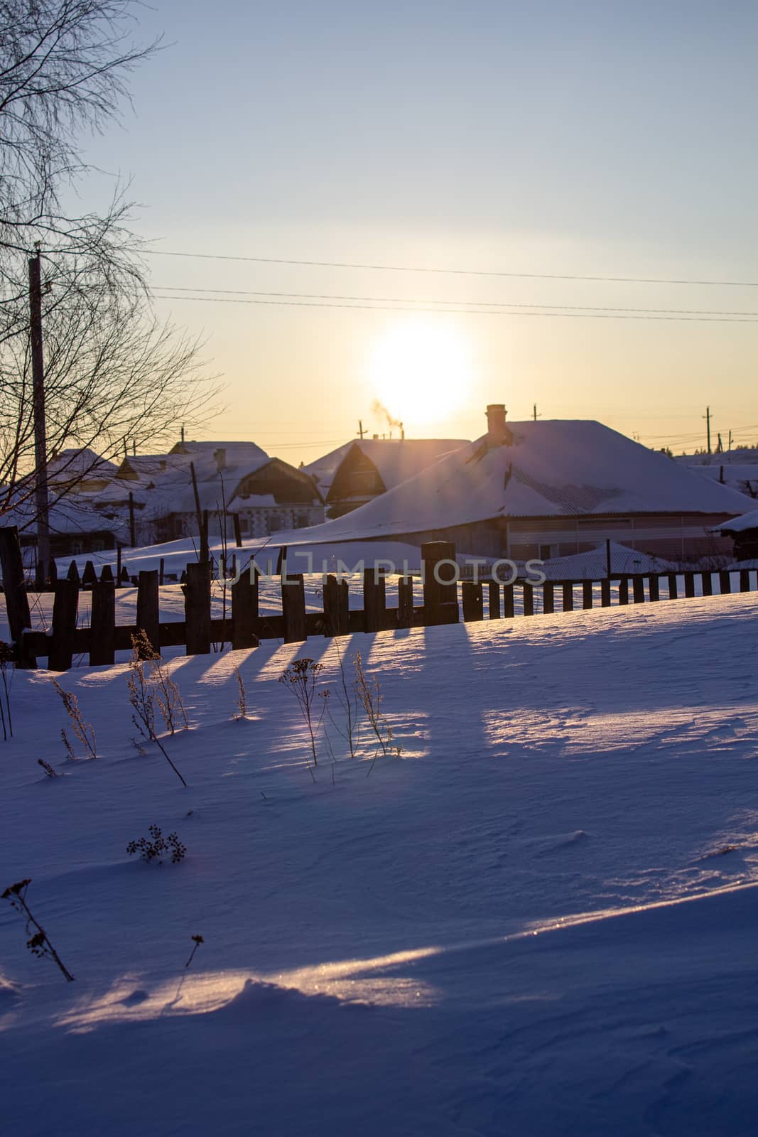 Wooden houses and fences covered with snow in Siberia, Russia