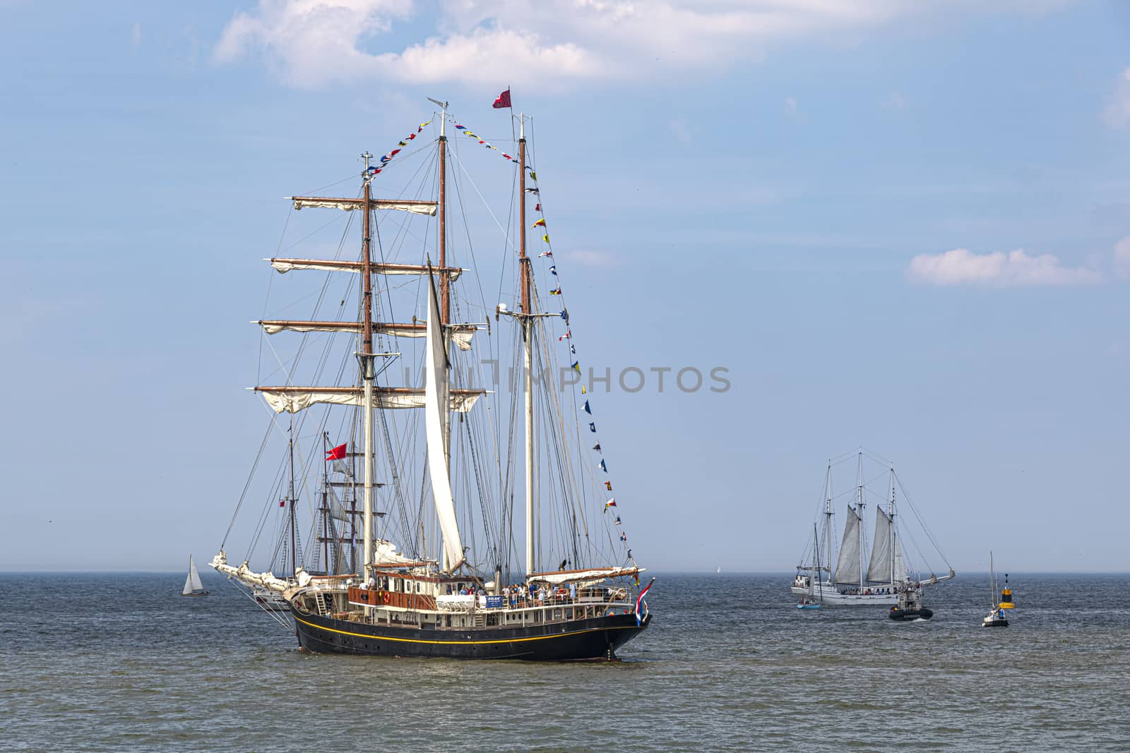 Antique tall ship, vessel leaving the harbor of The Hague, Scheveningen under a sunny and blue sky