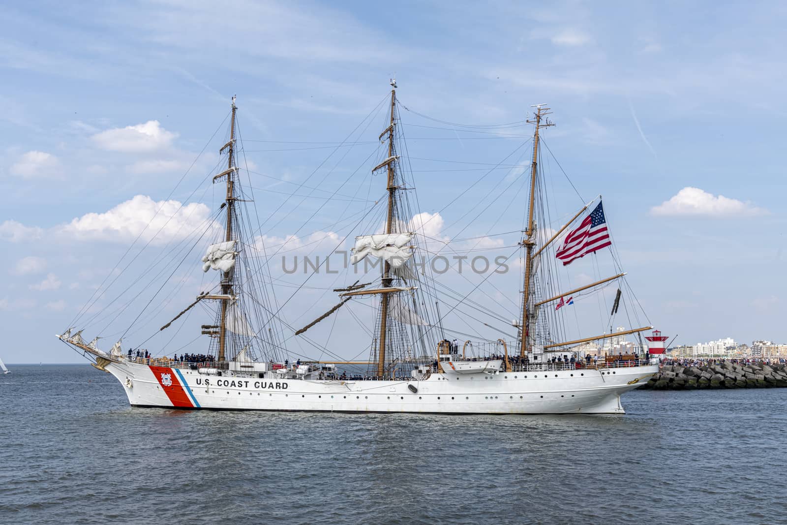 THE HAGUE, 23 June 2019 - US Coast Guard antique tall ship, vessel leaving the harbor of The Hague, Scheveningen under a sunny and blue sky by ankorlight