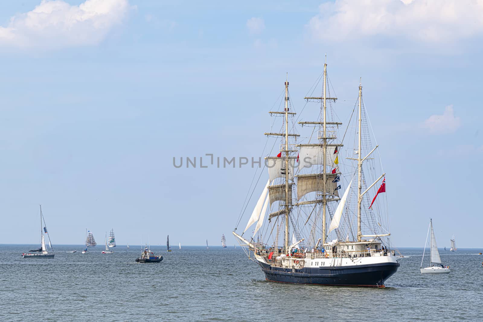 Antique tall ship, vessel leaving the harbor of The Hague, Scheveningen under a sunny and blue sky