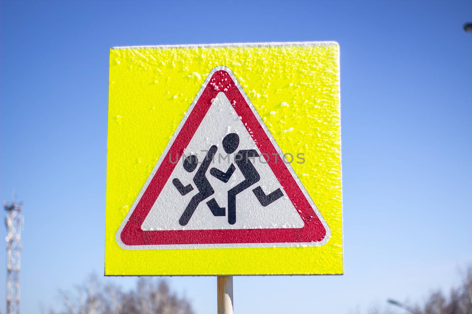 Pedestrian crossing sign on a yellow background. On a Sunny winter day