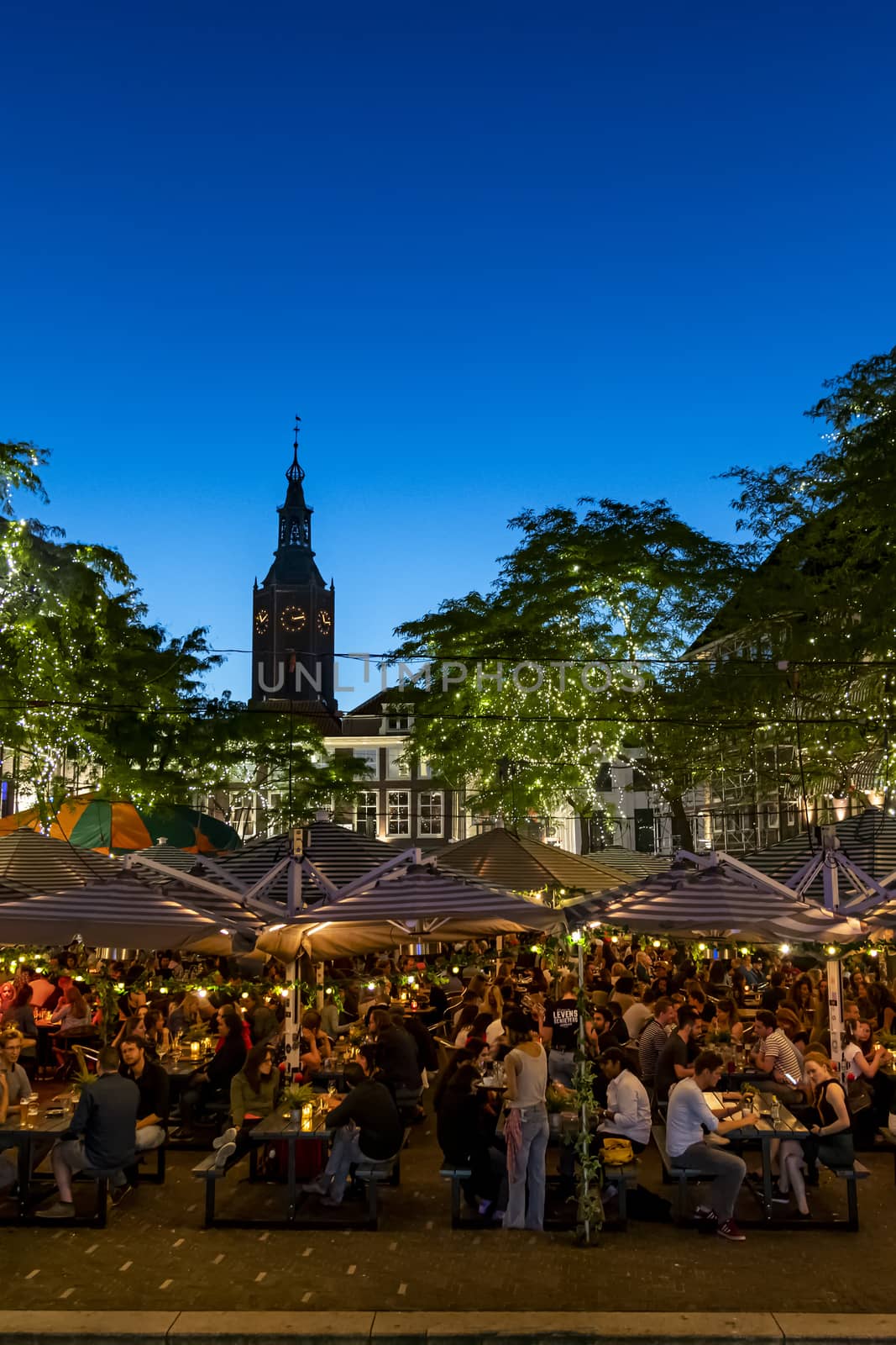 THE HAGUE, 28 June 2019 - City center restaurant bar crowded of people drinking and dining at the blue hour moment