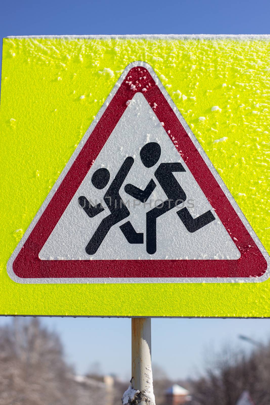 Pedestrian crossing sign on a yellow background. On a Sunny winter day. by AnatoliiFoto