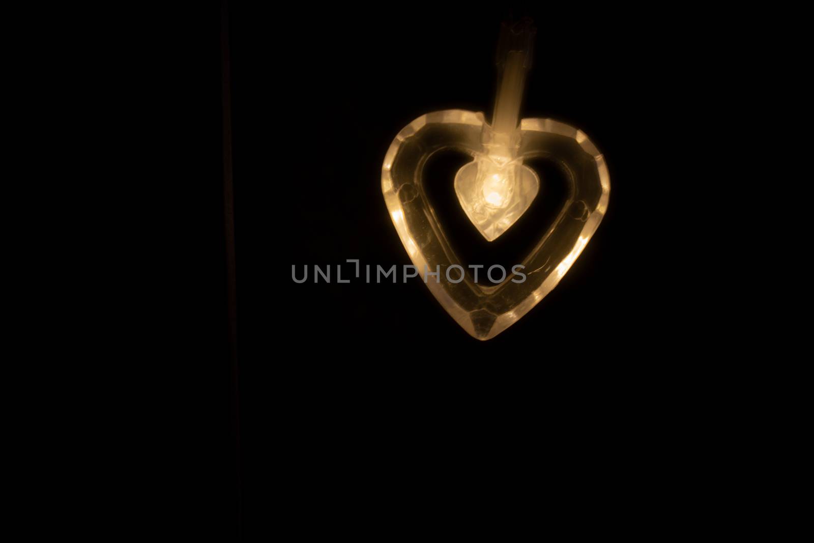 Heart-shaped light bulb in the dark.