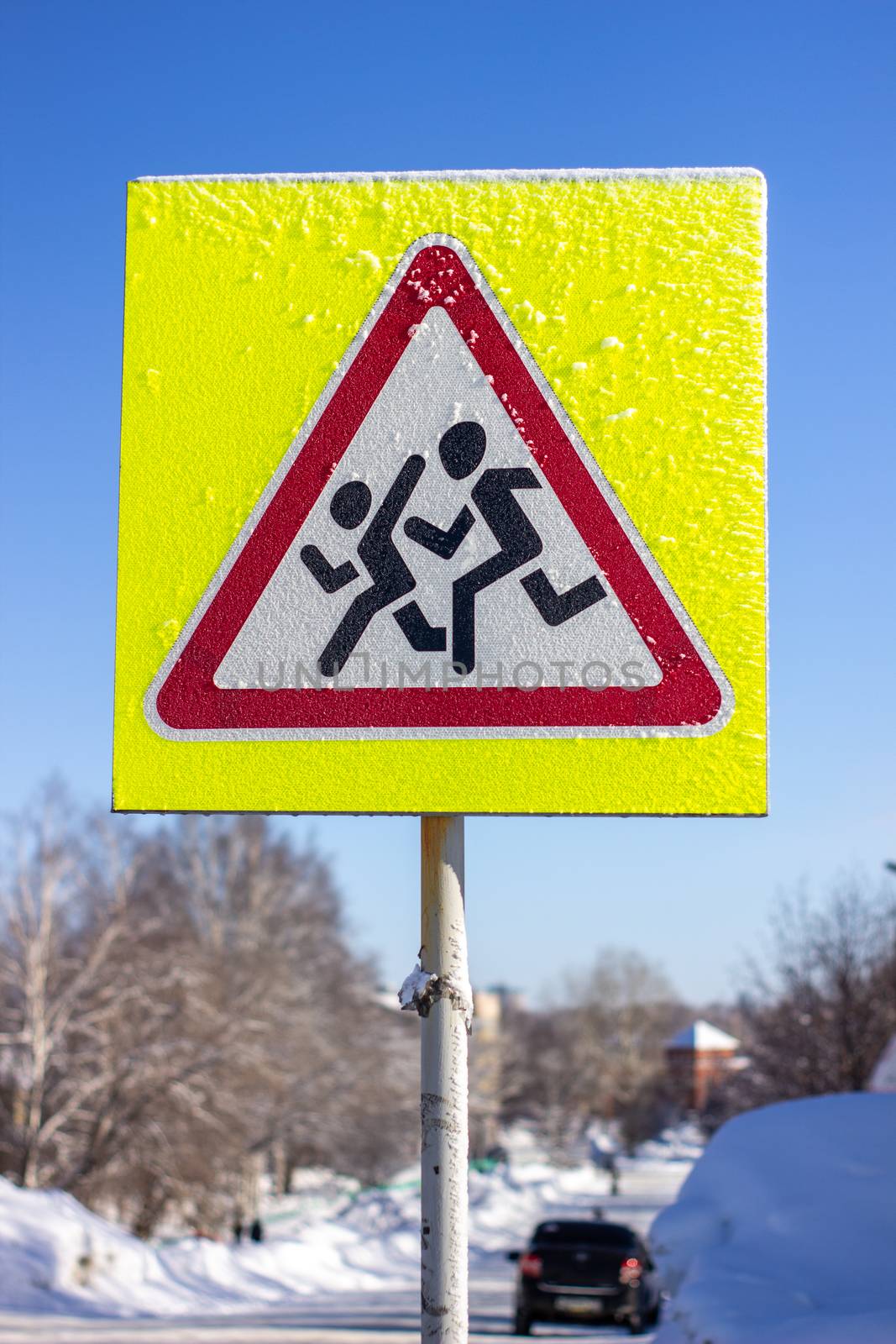 Pedestrian crossing sign on a yellow background. On a Sunny winter day. by AnatoliiFoto