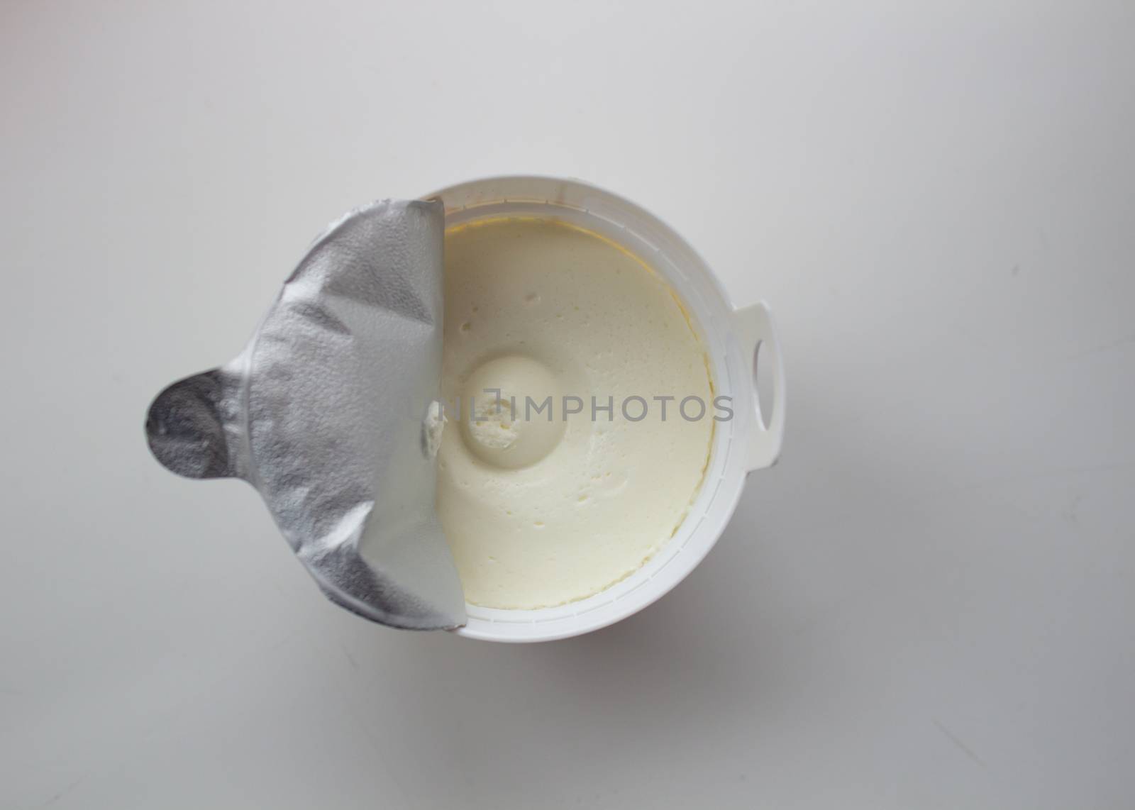 Cottage cheese in a container on a white background. by AnatoliiFoto