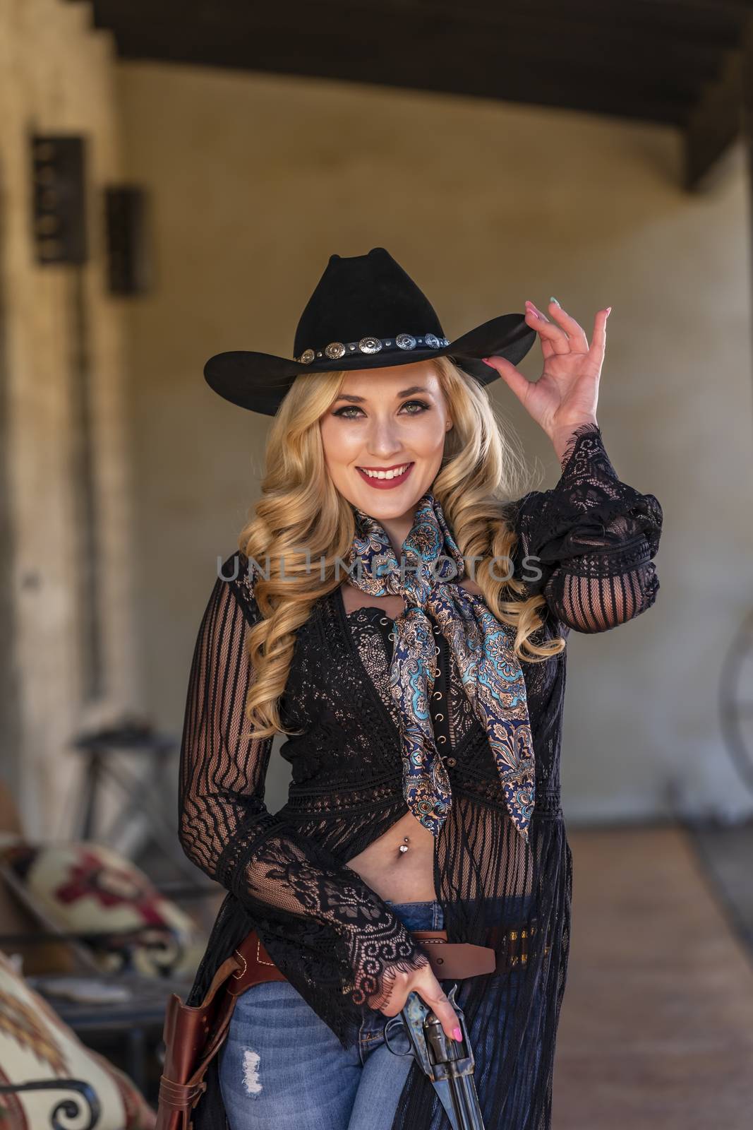 A gorgeous blonde model dressed as a cowgirl enjoying the outdoor weather