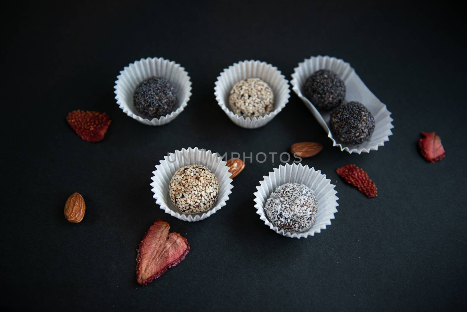 Top view of set handmade fruit and chocolate candies on a black background by marynkin