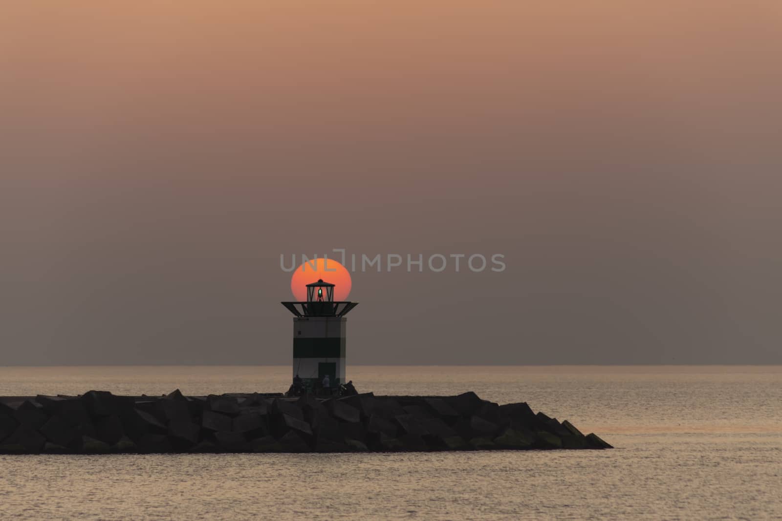 Sunset on the lighthouse of Scheveningen harbor at the summer hottest day ever