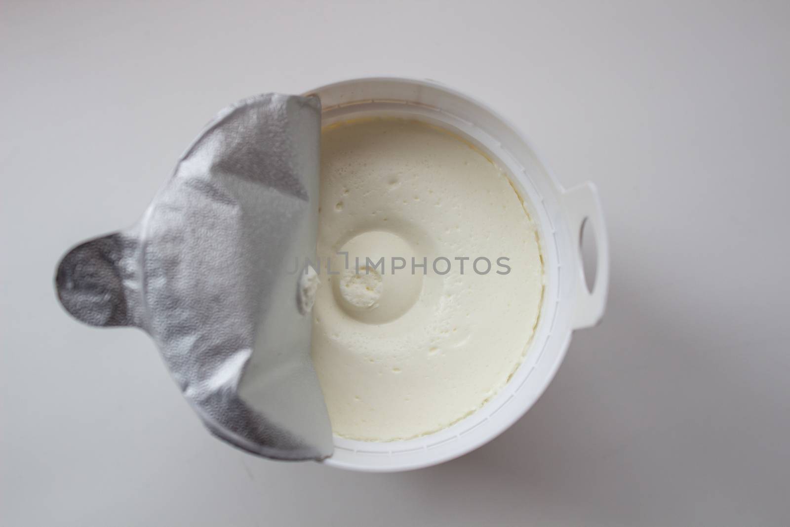 Cottage cheese in a container on a white background