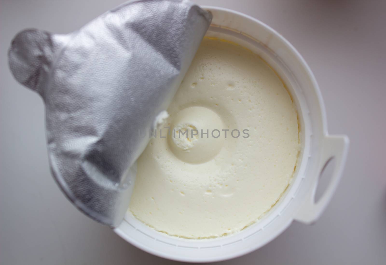 Cottage cheese in a container on a white background. by AnatoliiFoto