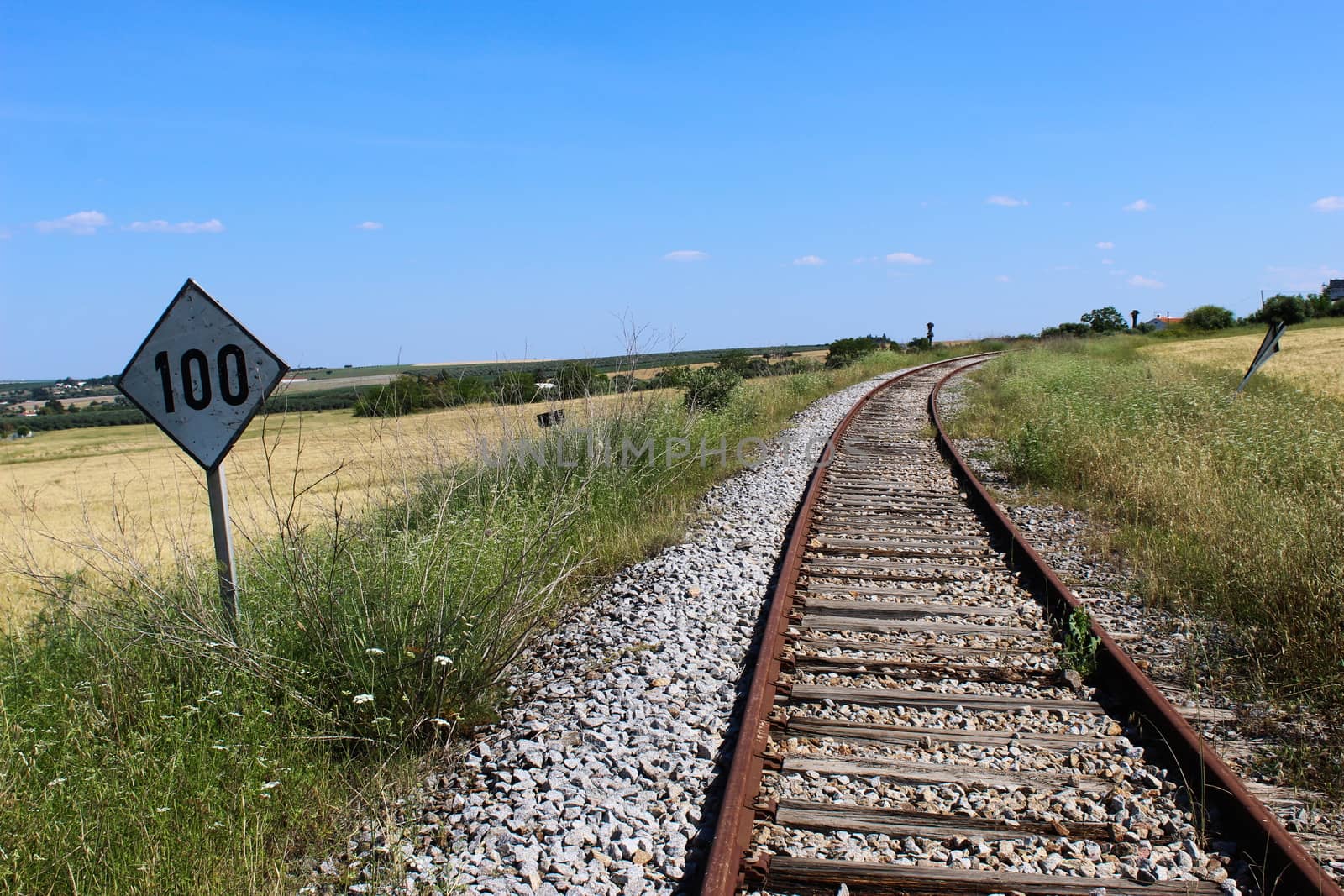 Old square sign with the number one hundred next to the old railroad. Beja, Portugal.