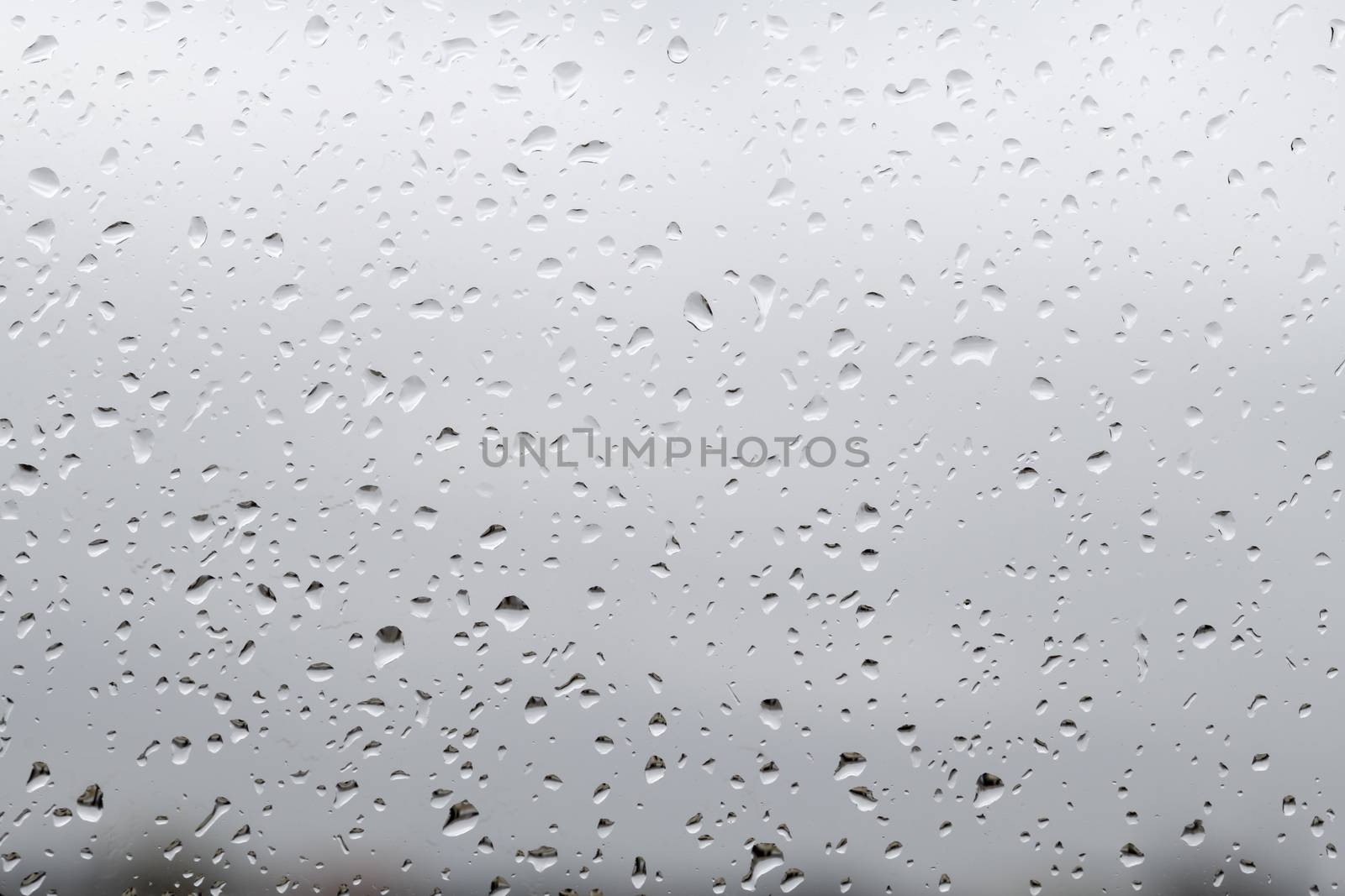 Raindrops at the raining day on the window glass agai by ankorlight