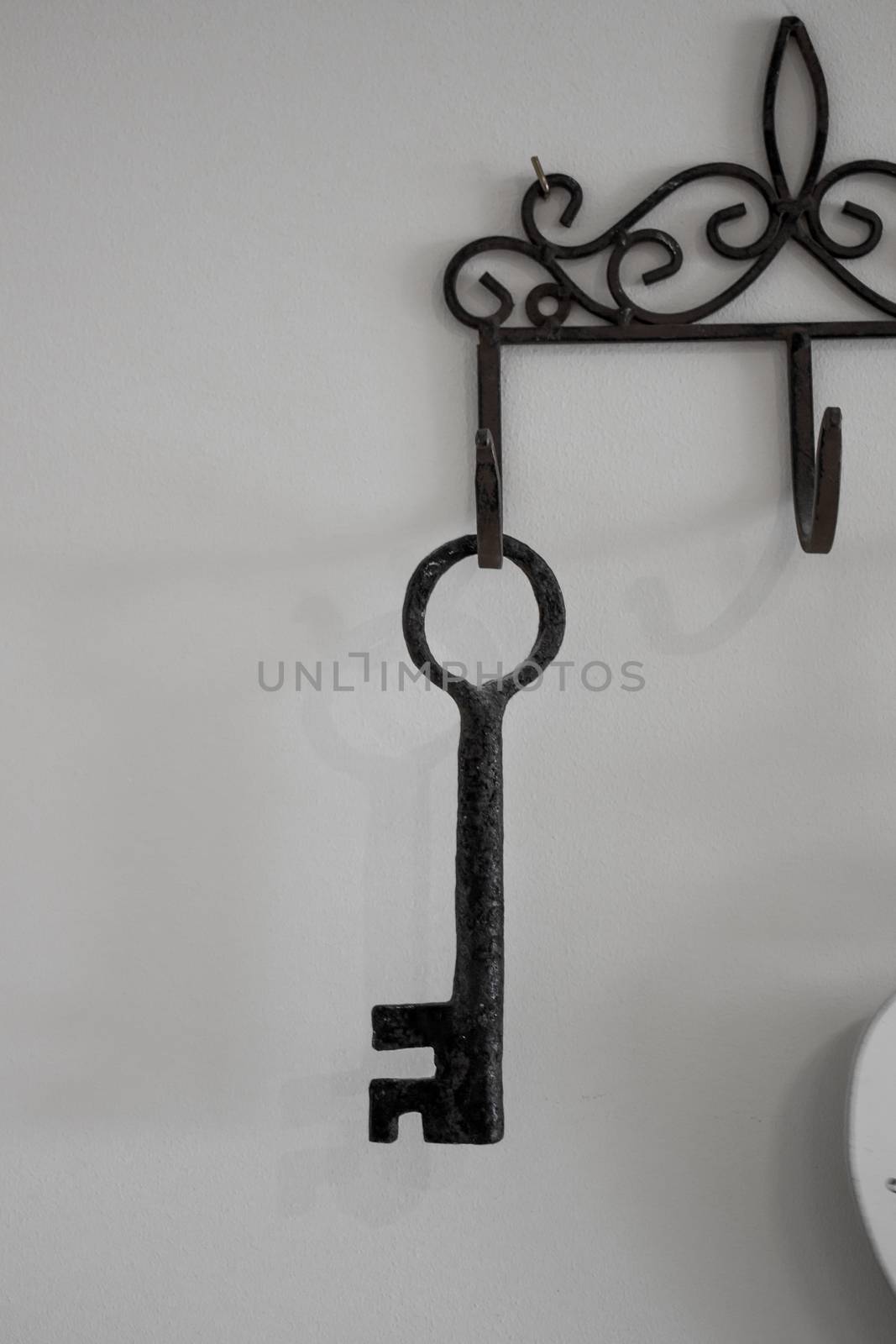 Keys hanging from hooks, on light wall background.