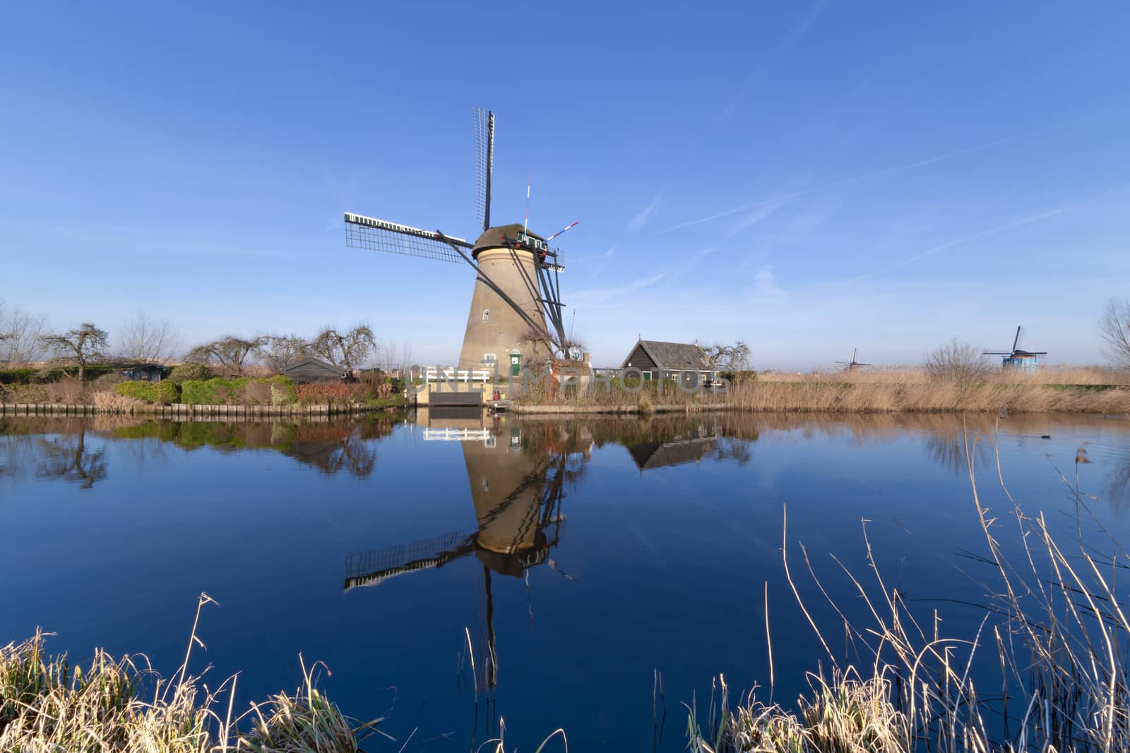 Early sunrise on the Unesco heritage windmill silhouette reflected on the calm water of the canal, Alblasserdam, Netherlands by ankorlight