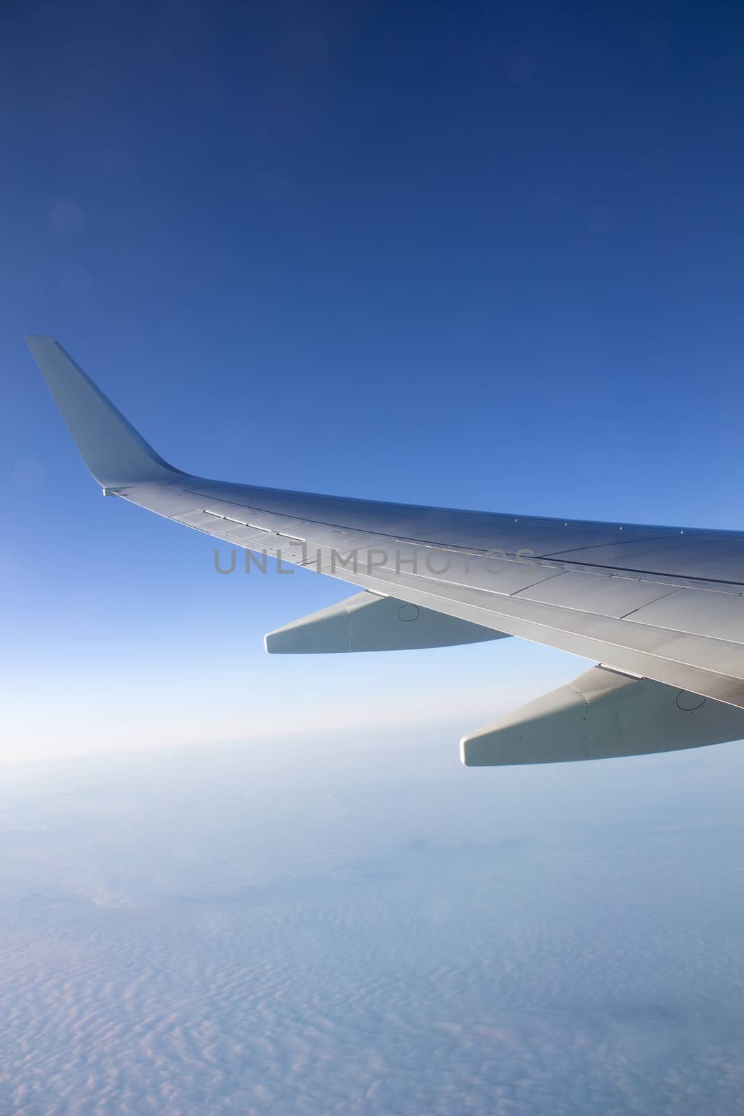 Airplane wing in the sky. View from a great height. by AnatoliiFoto