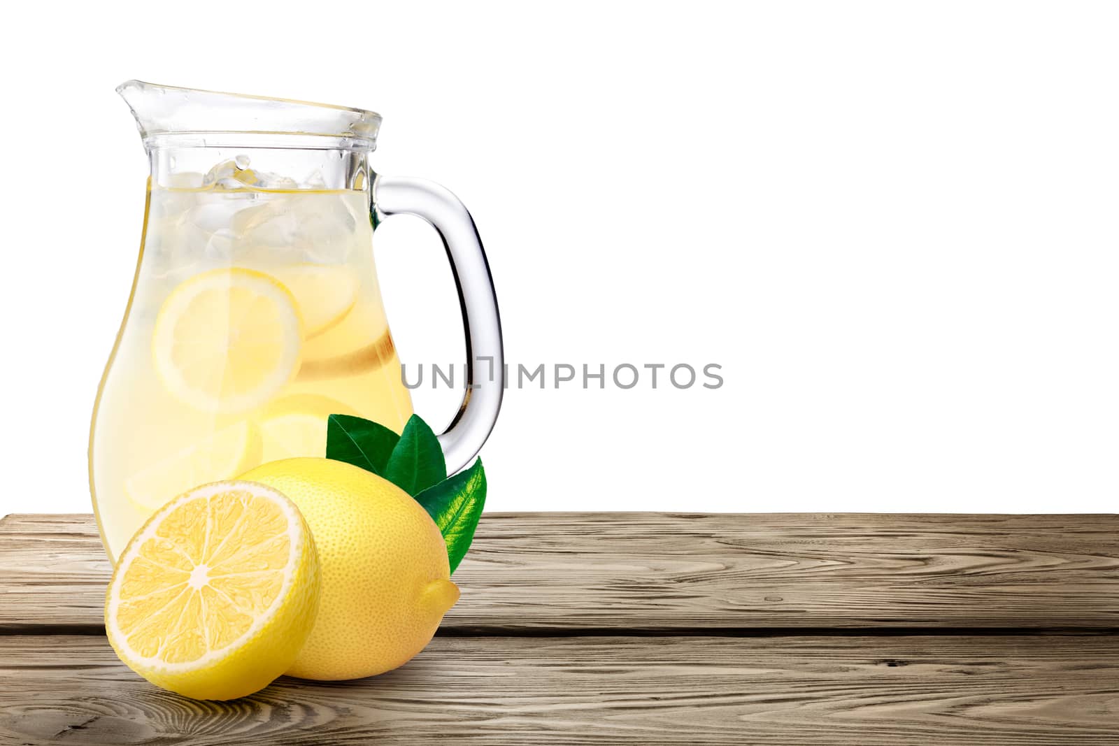 Lemonade pitcher with lemons on wooden table. Clipping paths, infinite depth of field