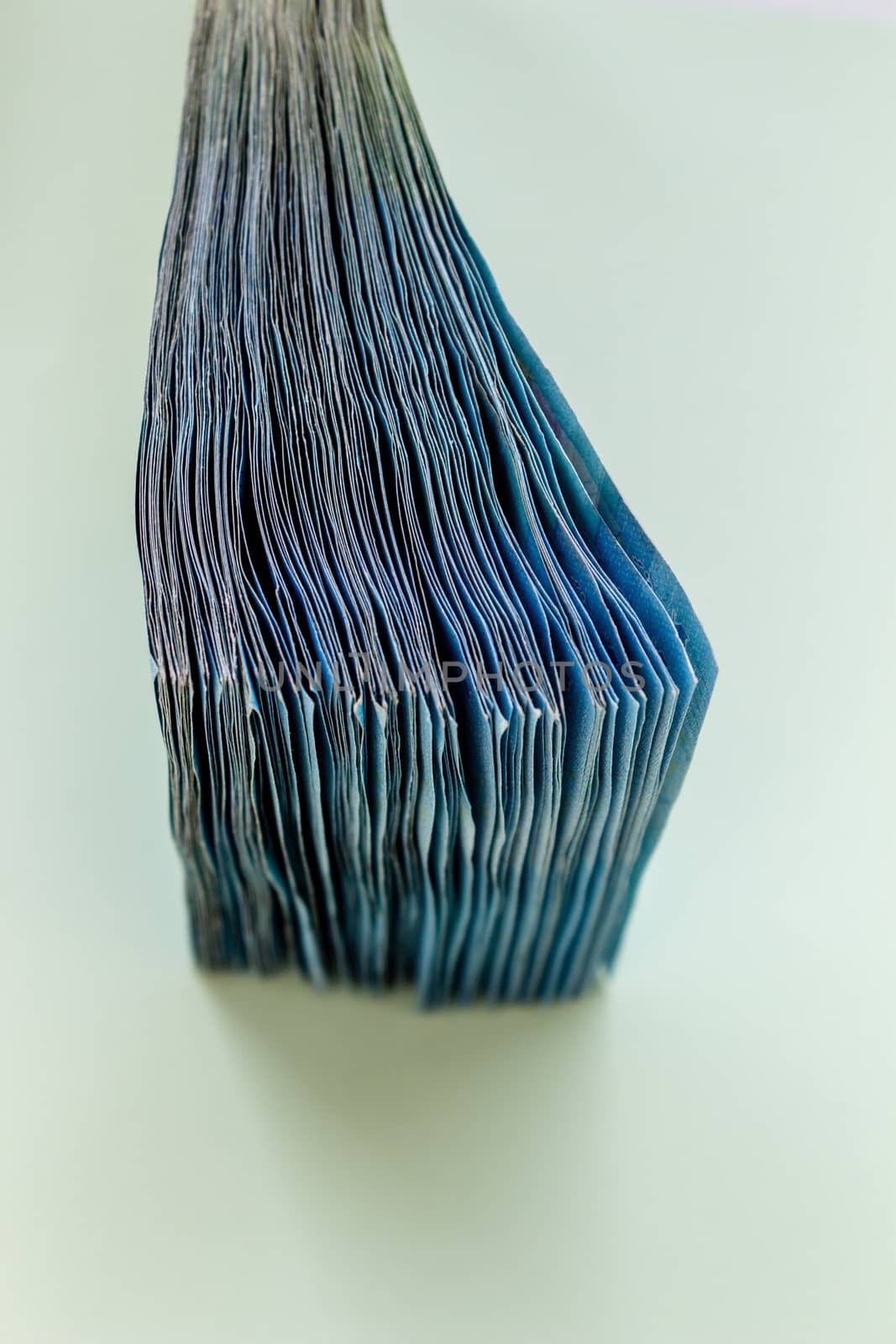 A bundle of 20 Euro banknotes and coins on a light background