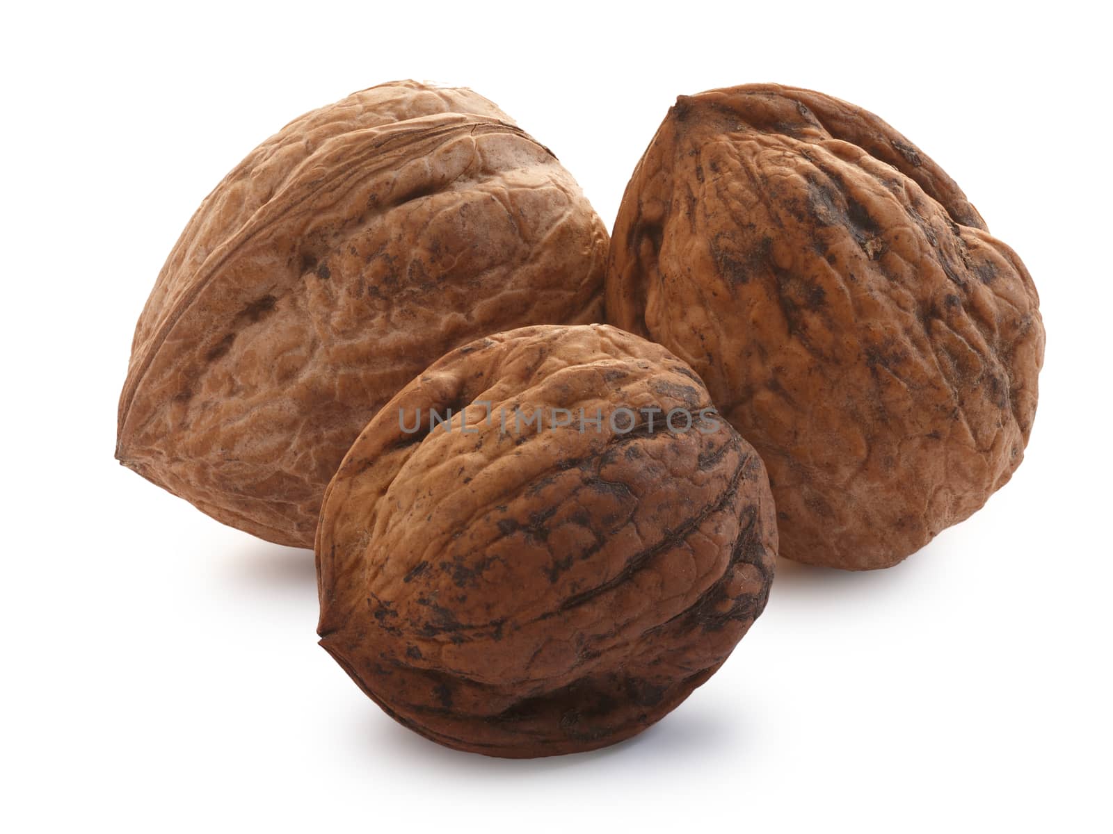 Three shelled whole walnuts (edible seed of tree of Juglans regia). Clipping paths for both nut and shadow, infinite depth of field