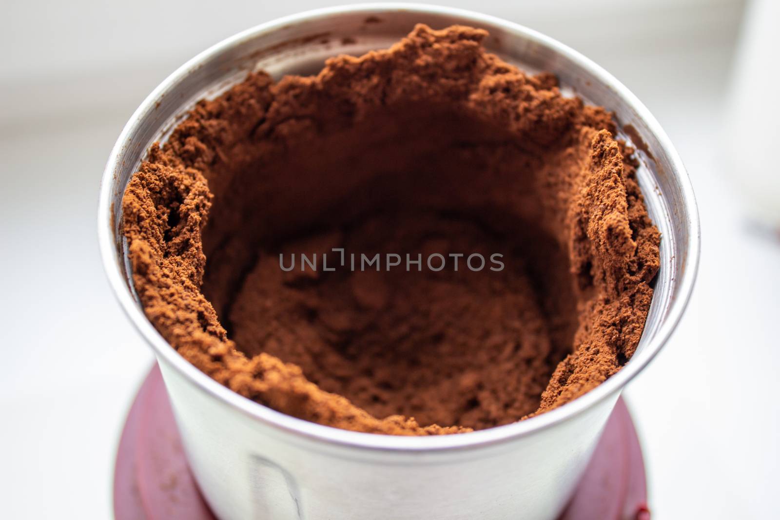 High angle view of fresh coffee pouring out of a coffee grinder into a portafilter for a professional espresso machine