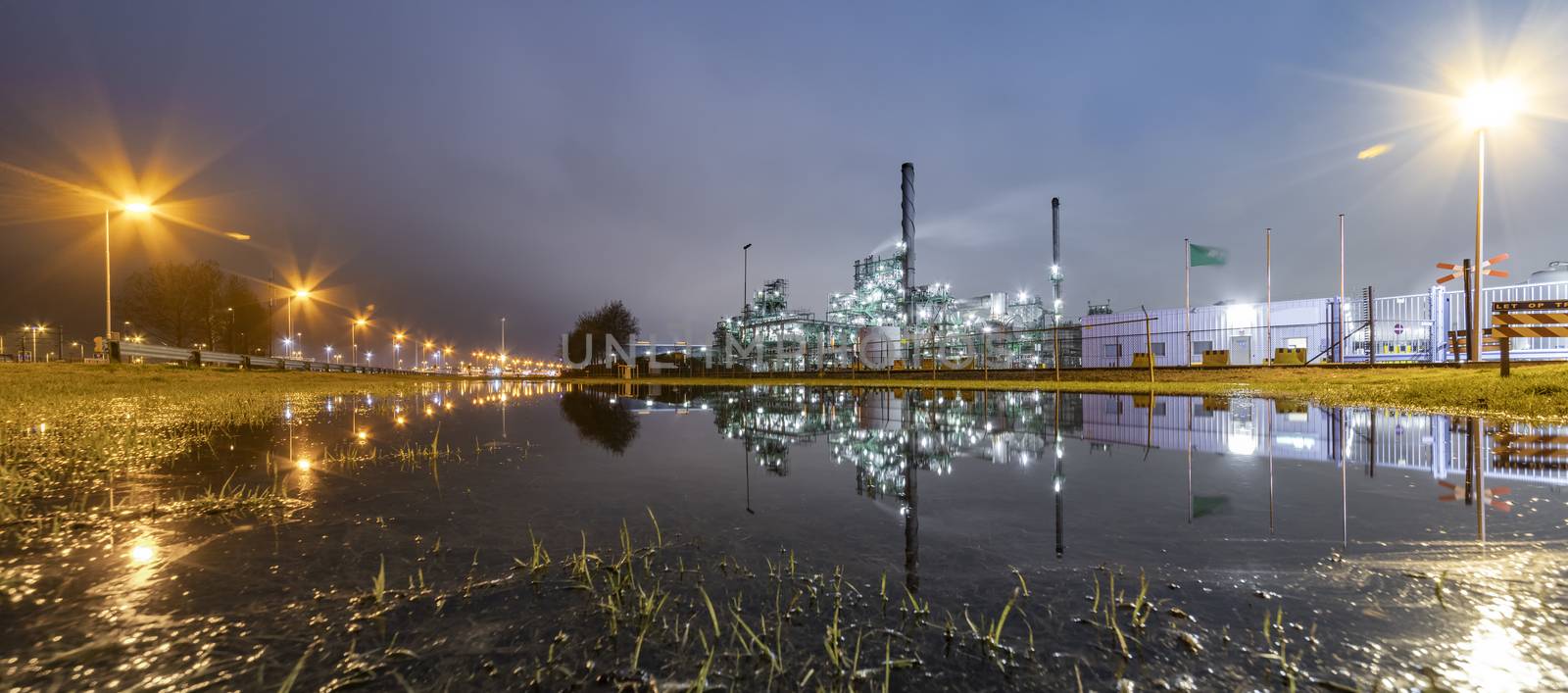 Reflection of the panorama of a refinery and its chimney during the sunset blue hour moment at Rotterdam, Netherlands by ankorlight