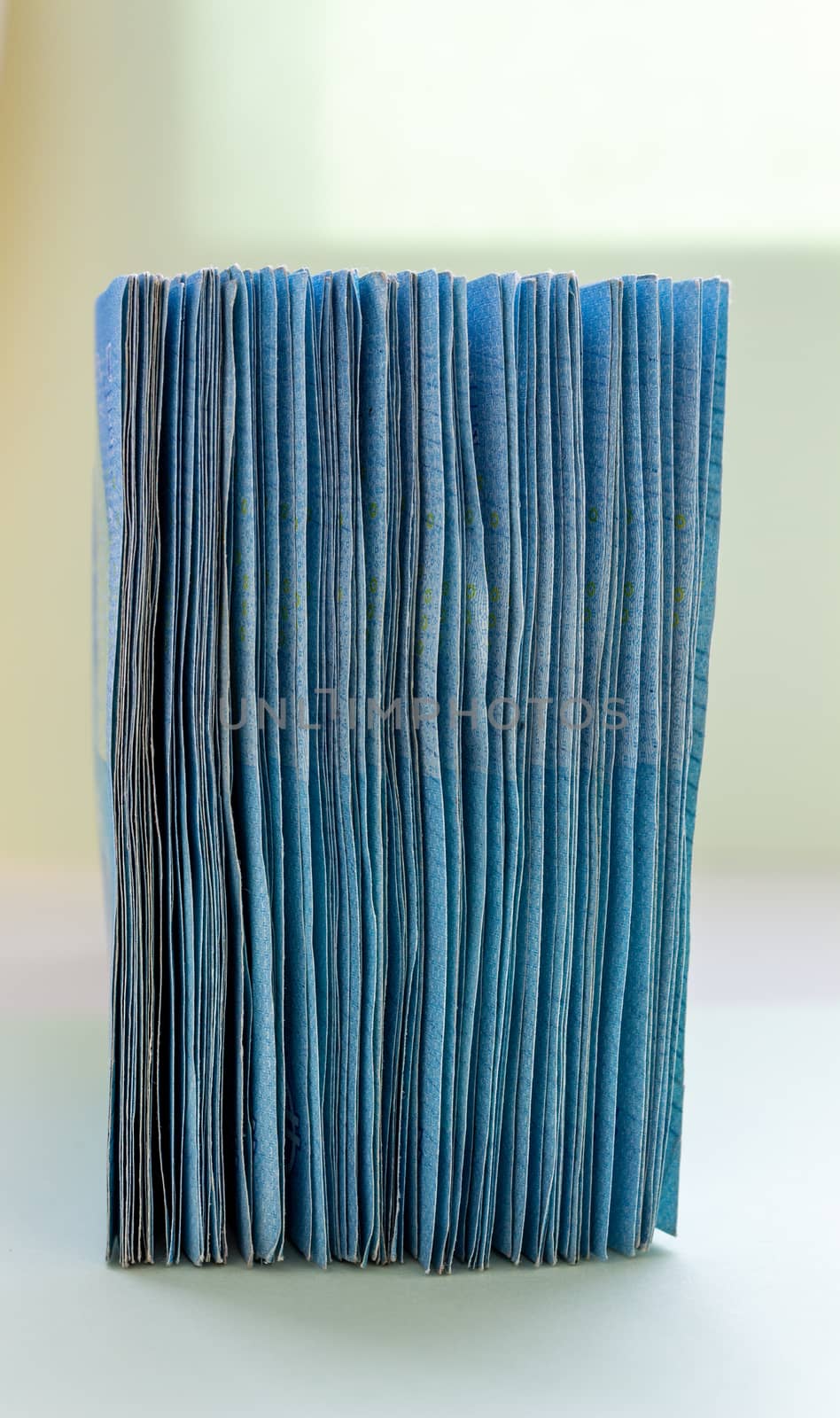 A bundle of 20 Euro banknotes and coins on a light background