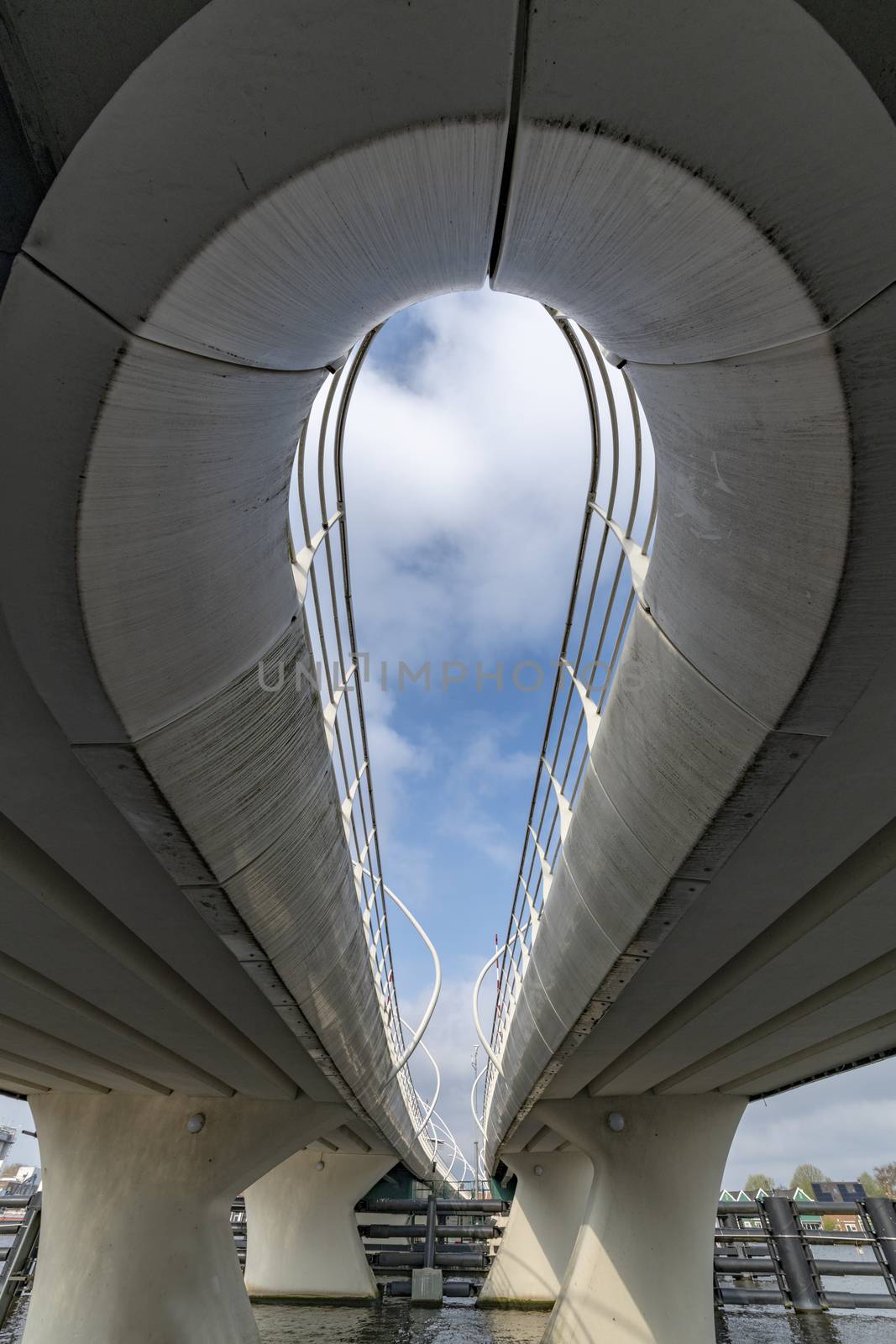 Curvy bridge structure viewed from below at the Amstel river level by ankorlight