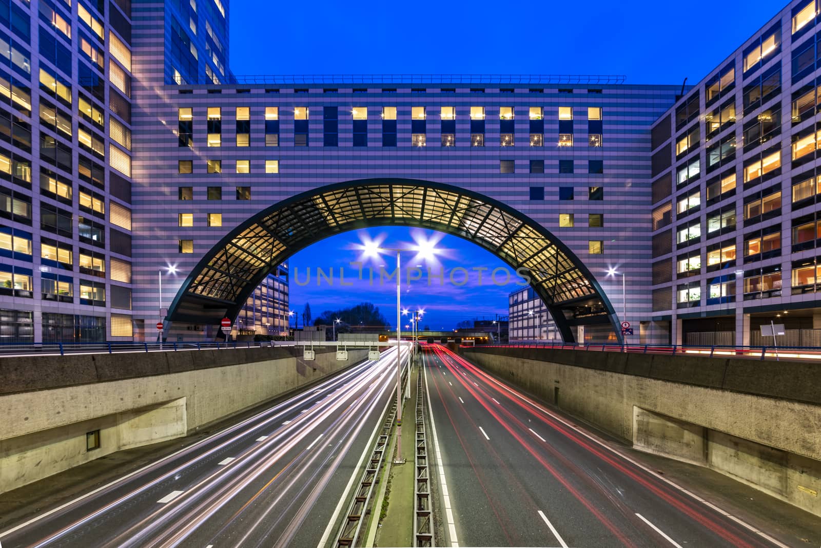 Buildings over the end of A12 highway entering inside The Hague city during the blue hours, Netherlands by ankorlight