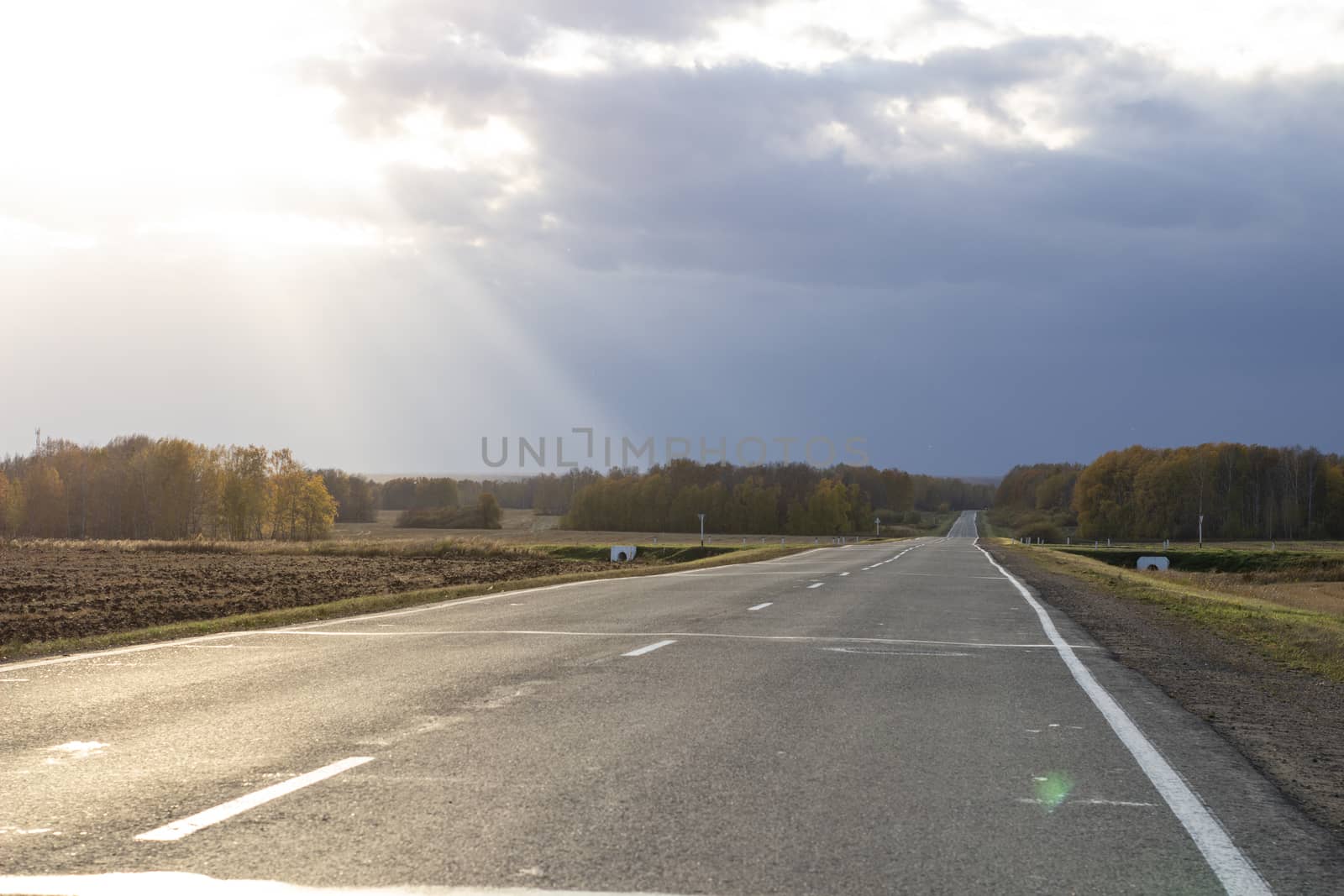 Large paved road in the middle of the field. Greater depth of field