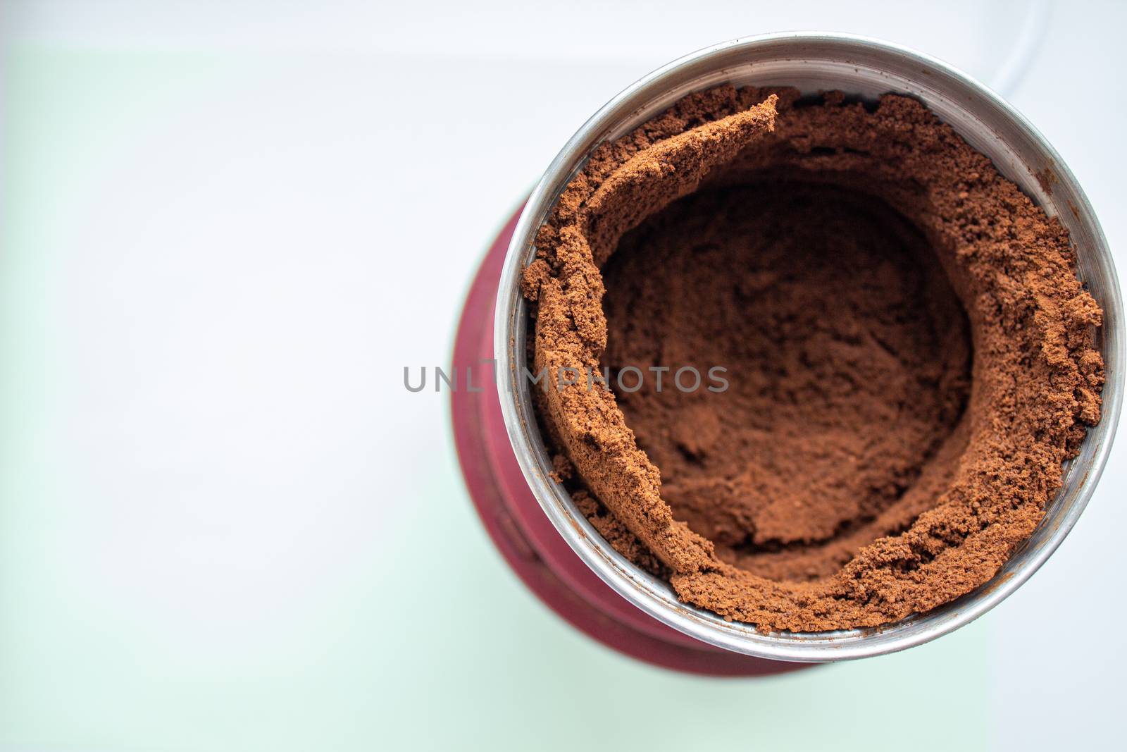 High angle view of fresh coffee pouring out of a coffee grinder into a portafilter for a professional espresso machine