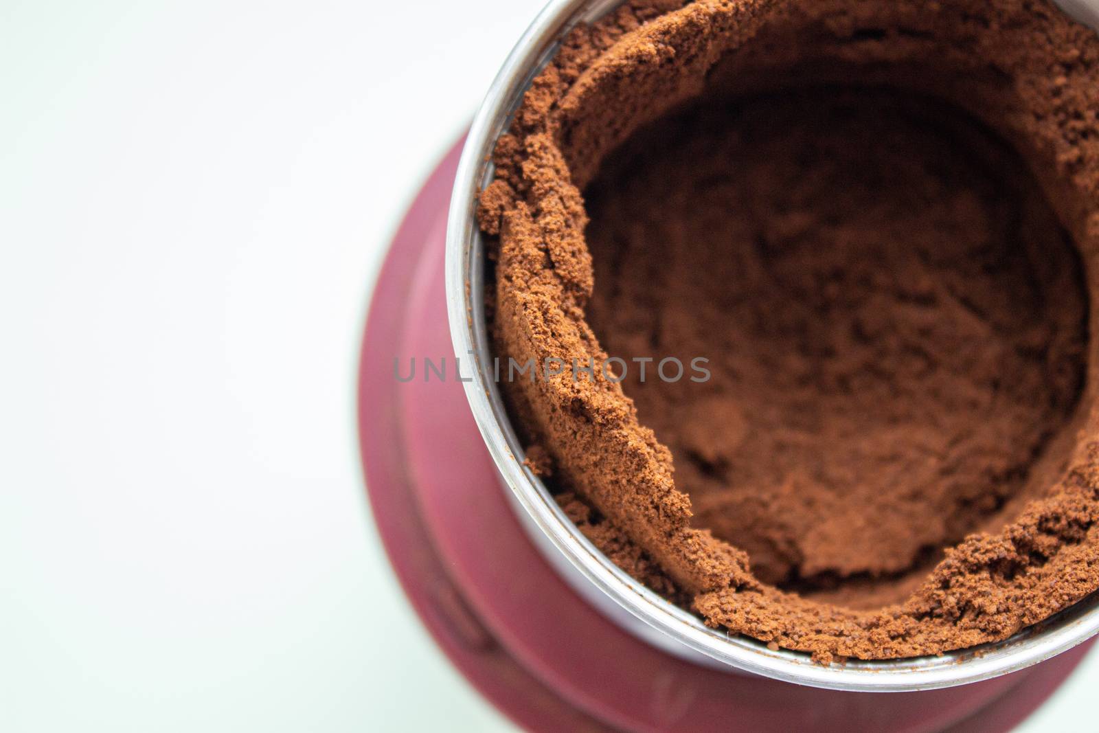 High angle view of fresh coffee pouring out of a coffee grinder into a portafilter for a professional espresso machine