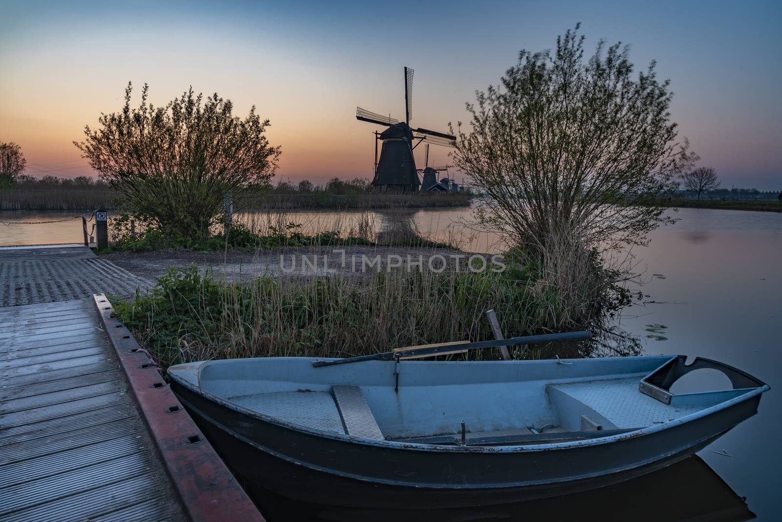 Safety boat parking at the bench of the kinderdijk canal at the golden hour sunrise