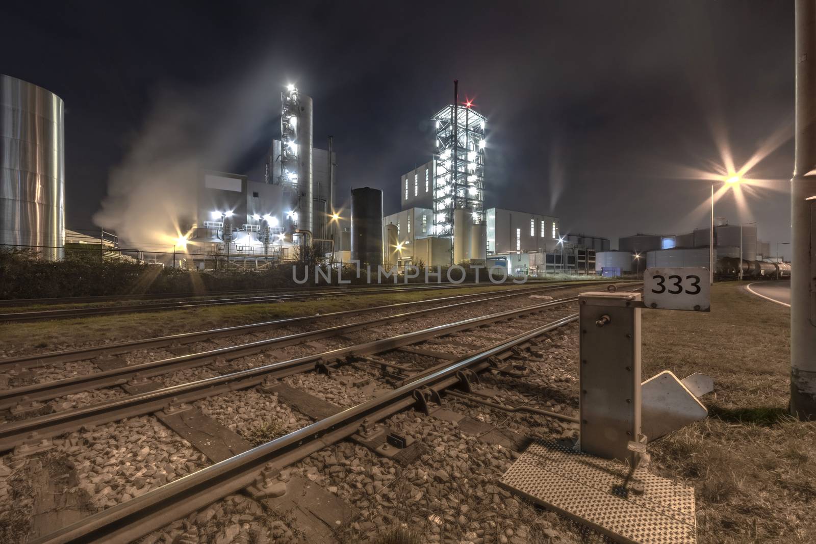 Night view of an industrial zone with the rail road checkpoint transporting in and out raw material