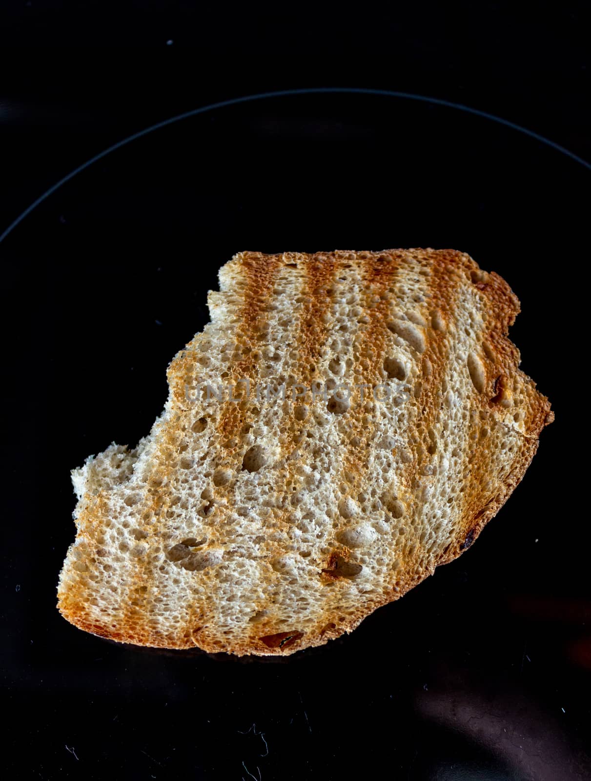 A piece of bread for toast on a dark background.