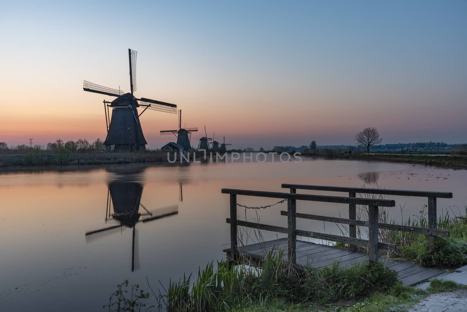 Twight light sunrise on the Unesco heritage windmill silhouette at the middle of the canal, Alblasserdam, Netherlands by ankorlight