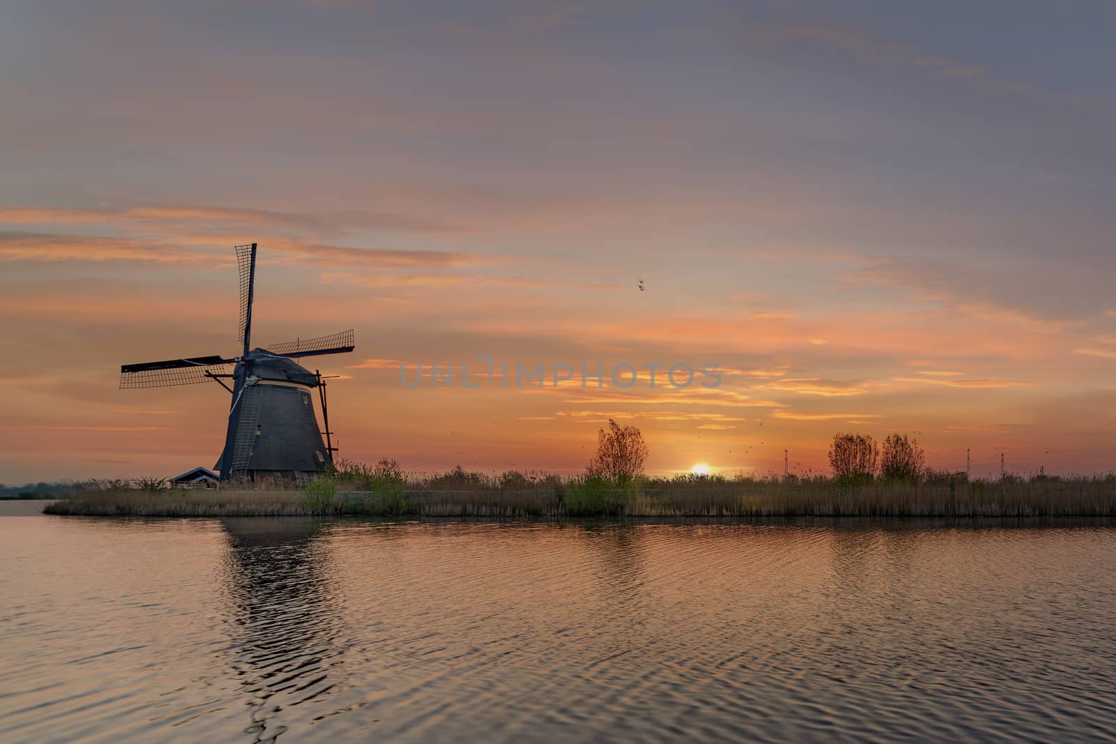 Long exposure of the Kinderdjik windmill sunrise reflection on the calm water of the Alblasserdam canal  by ankorlight