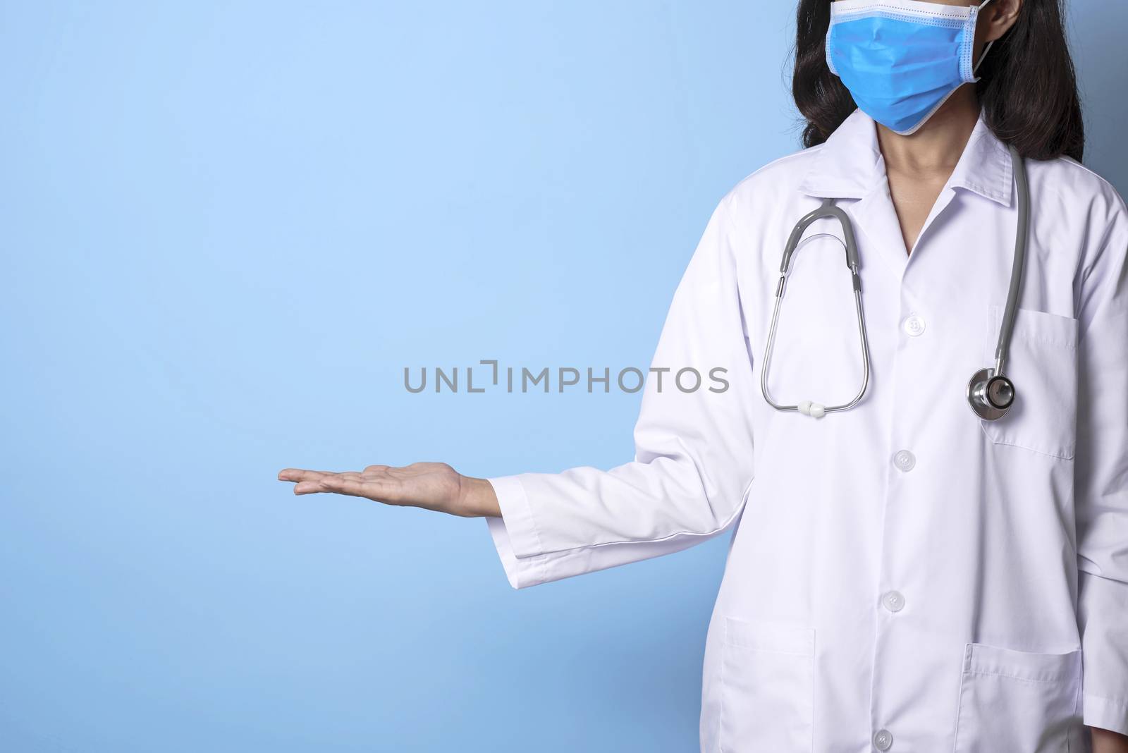 doctor wearing mask covering mouth and nose and gesture hand point to copy space.